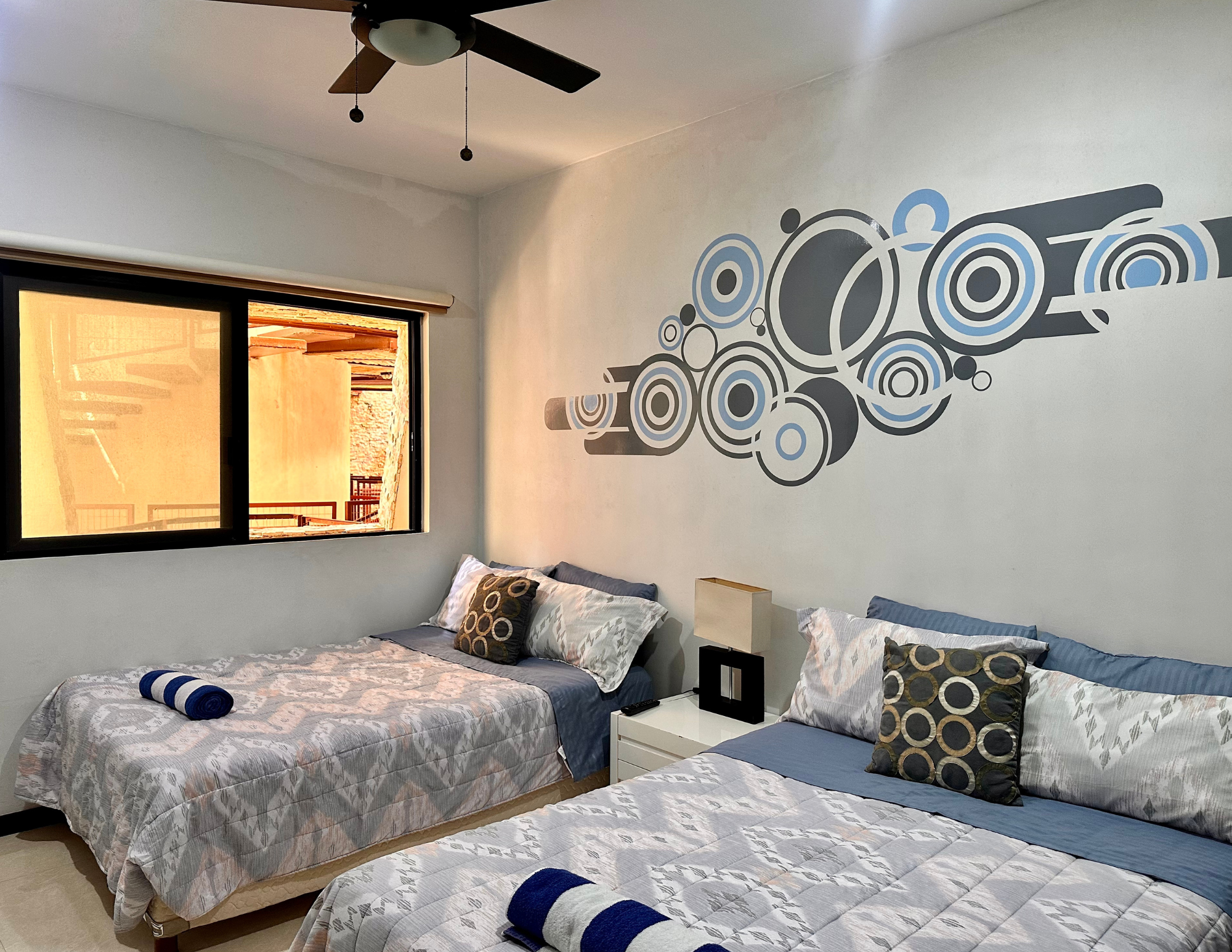 Two beds in modern bedroom with wall mural