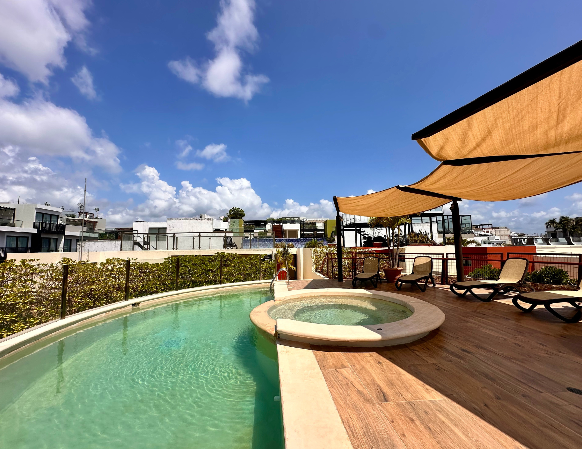 Rooftop pool and jacuzzi with lounge chairs