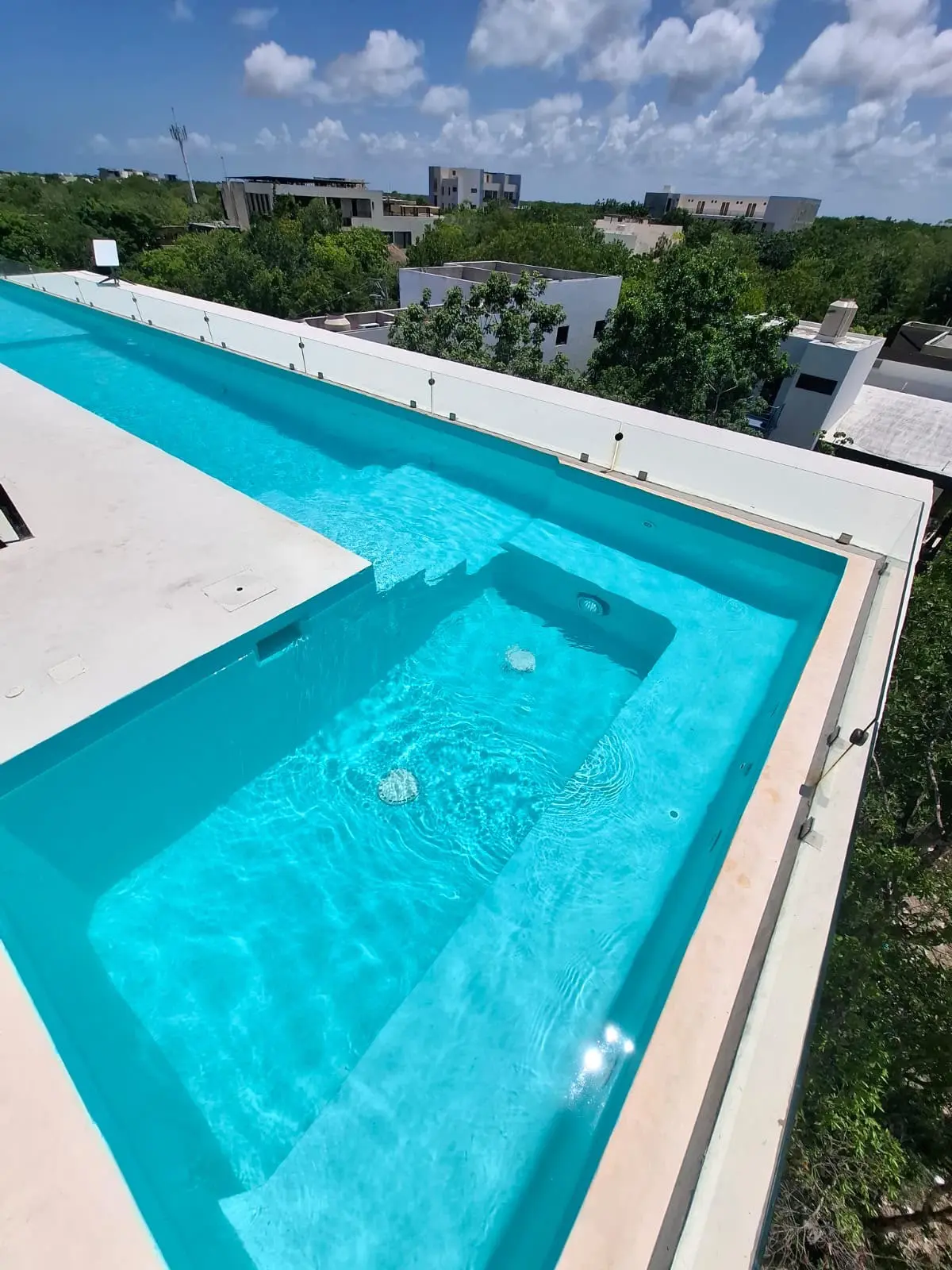 Rooftop turquoise lap pool with city view