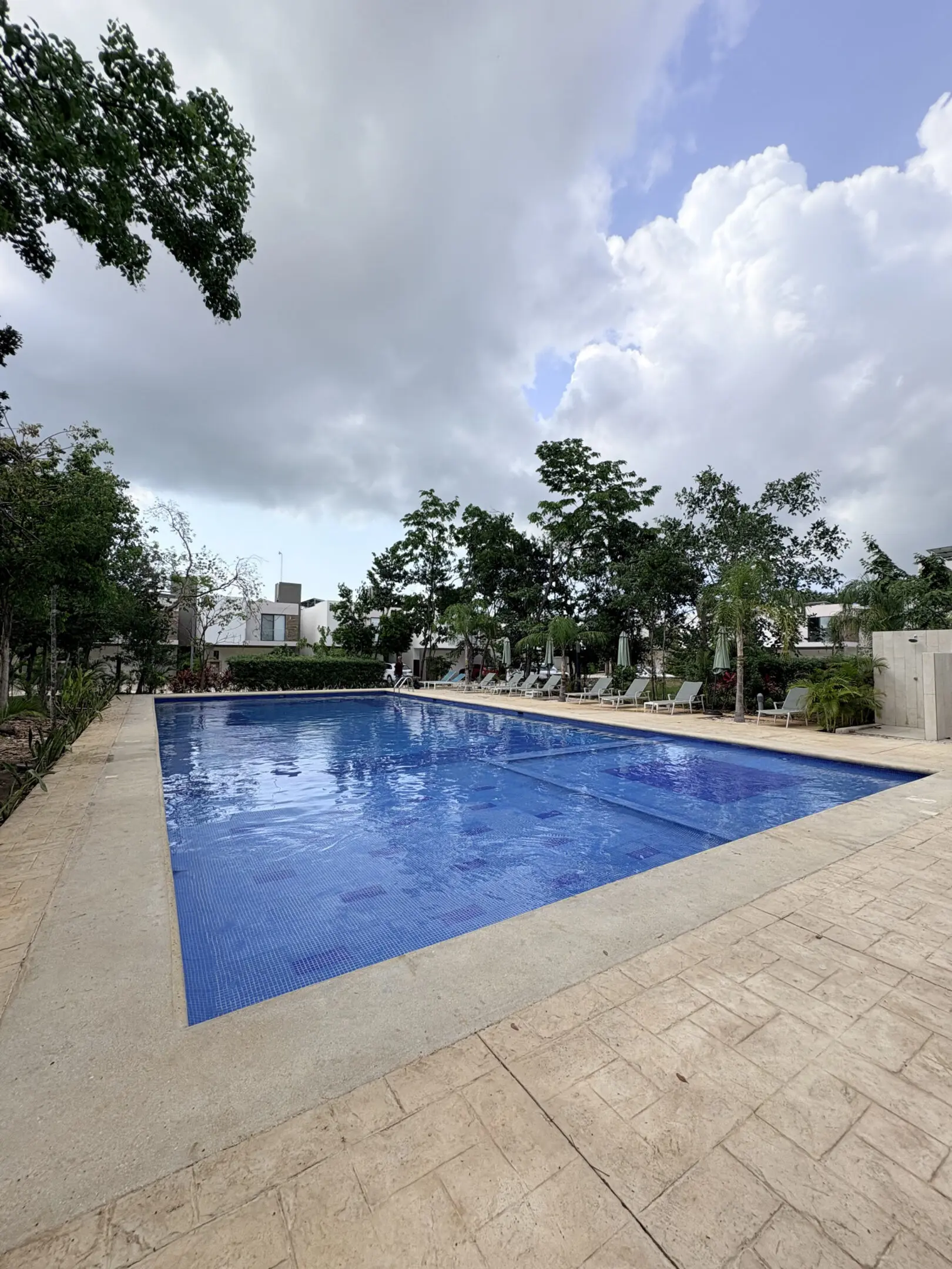 Blue tiled outdoor pool with lounge chairs
