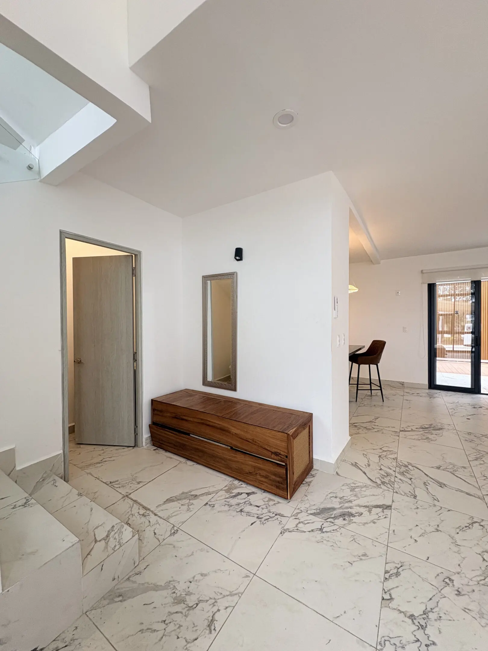 Modern foyer with wooden bench and marble floors
