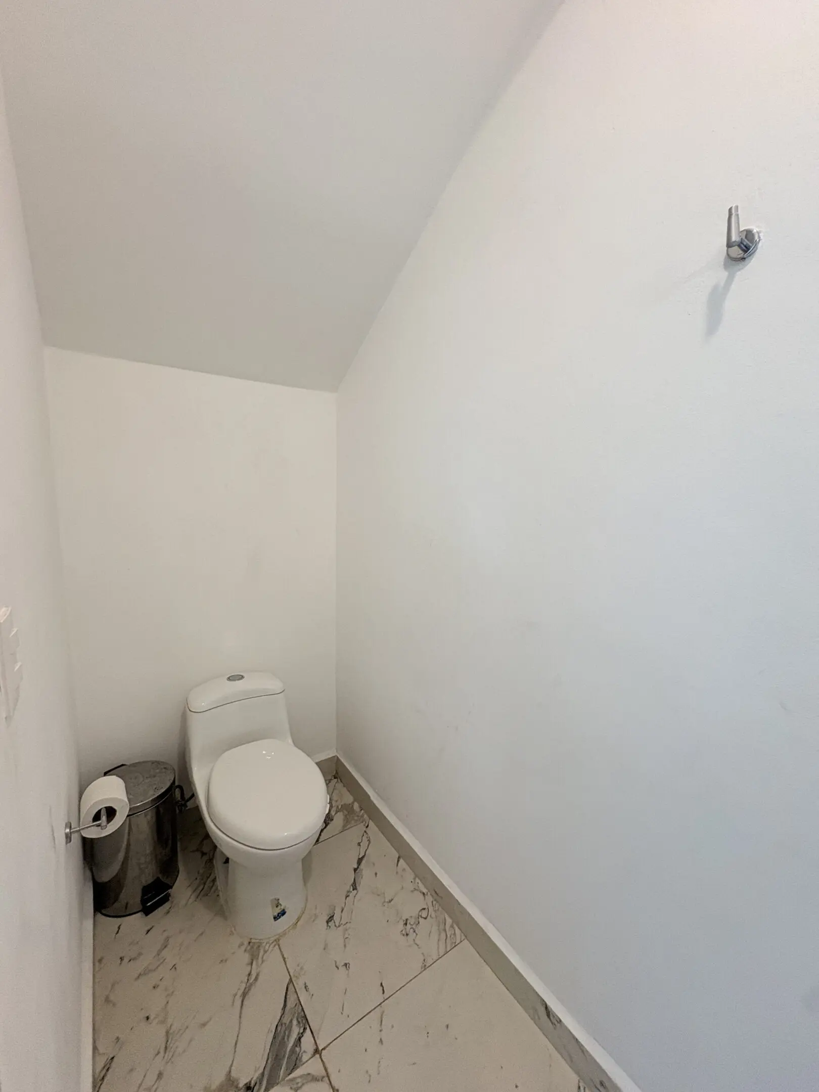Compact white toilet room with marble floor