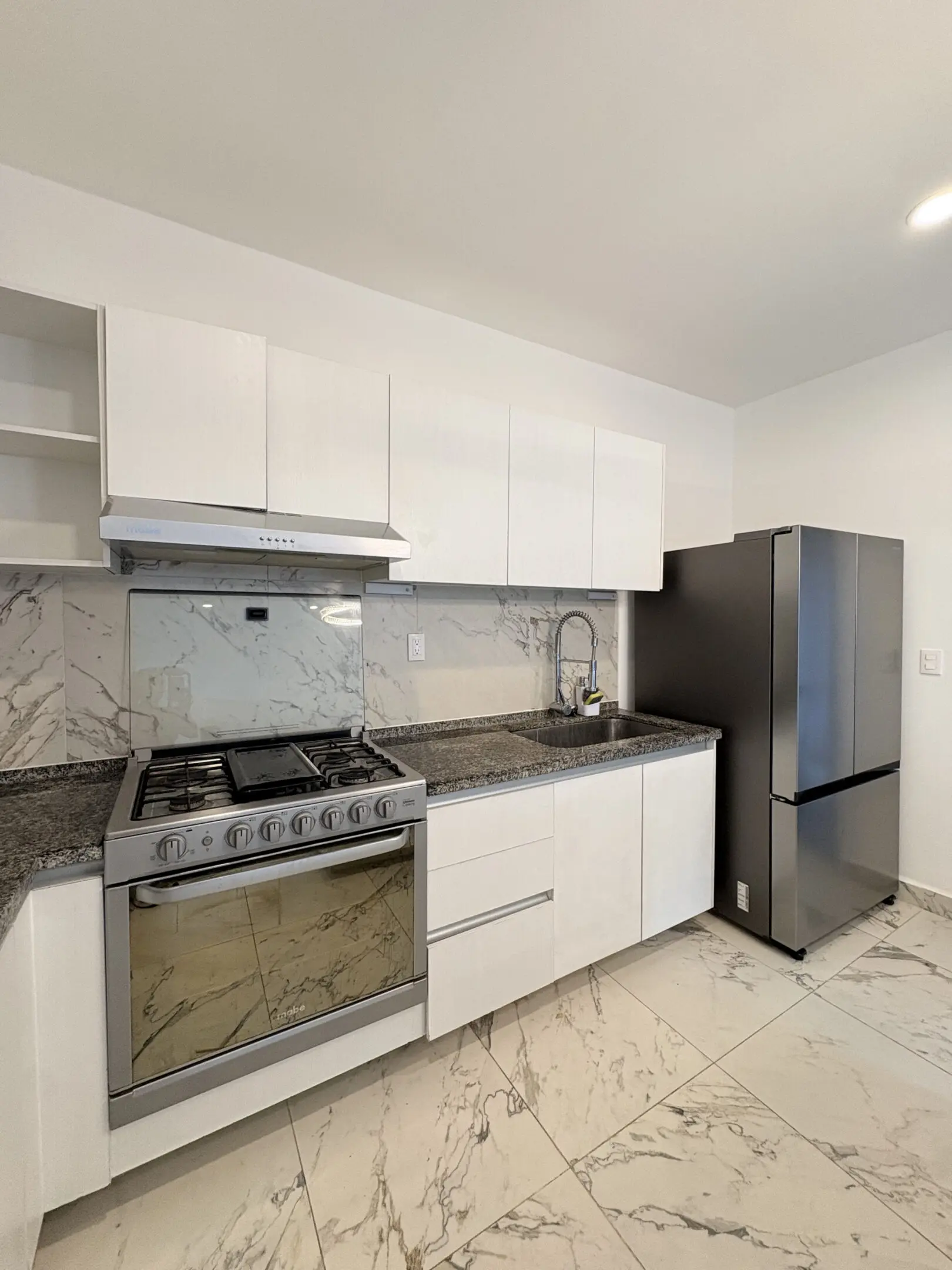 Modern white kitchen with stainless appliances