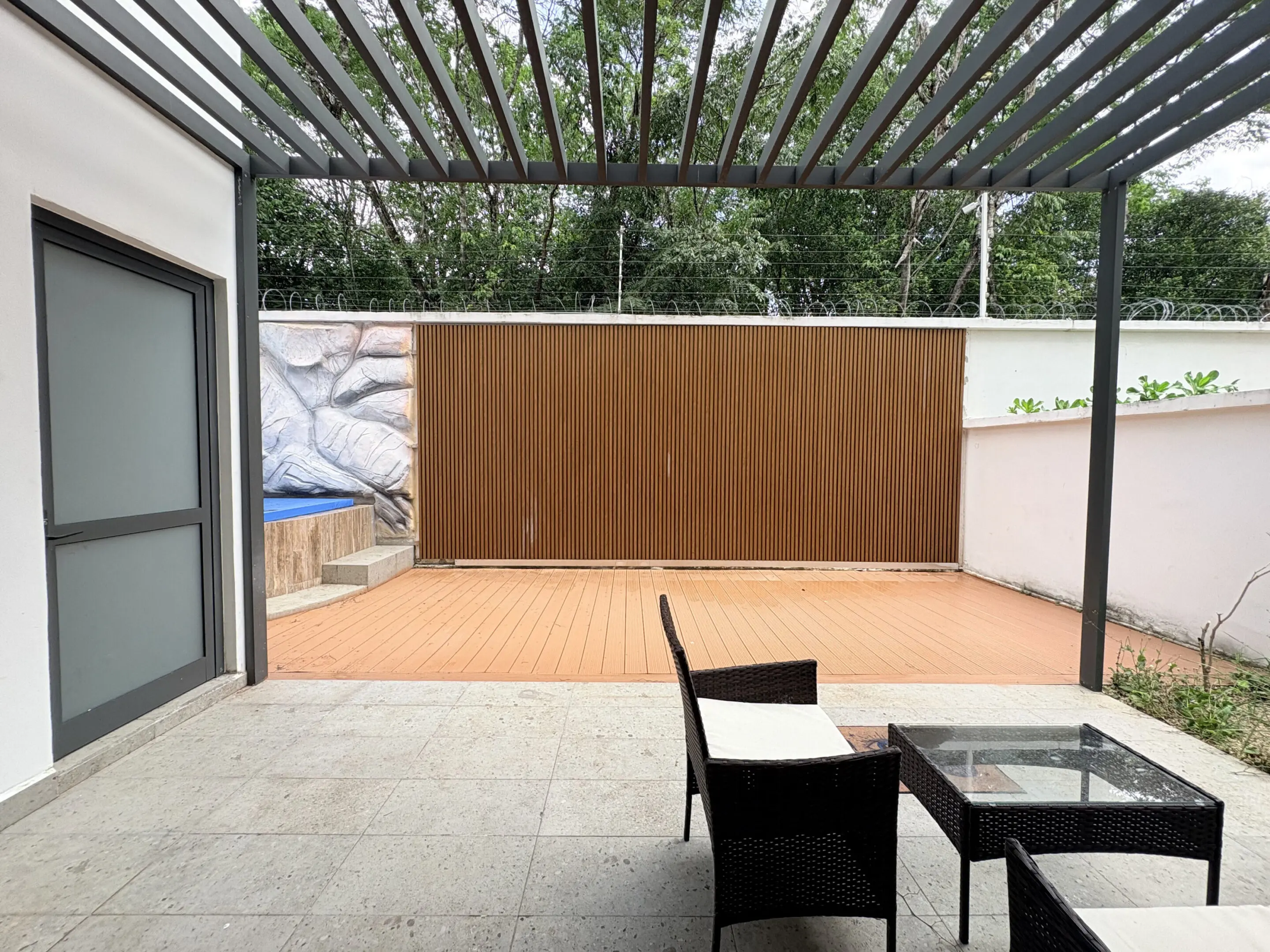 Covered patio with wicker chairs and wooden deck