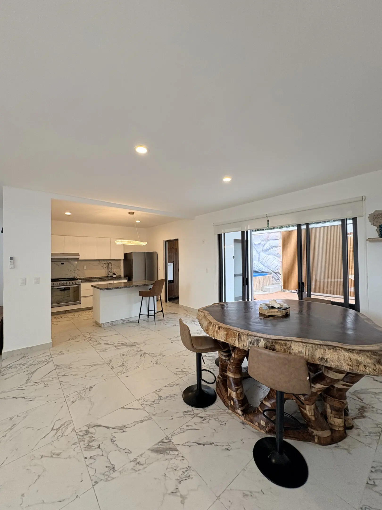 Modern open-plan kitchen with wooden round table