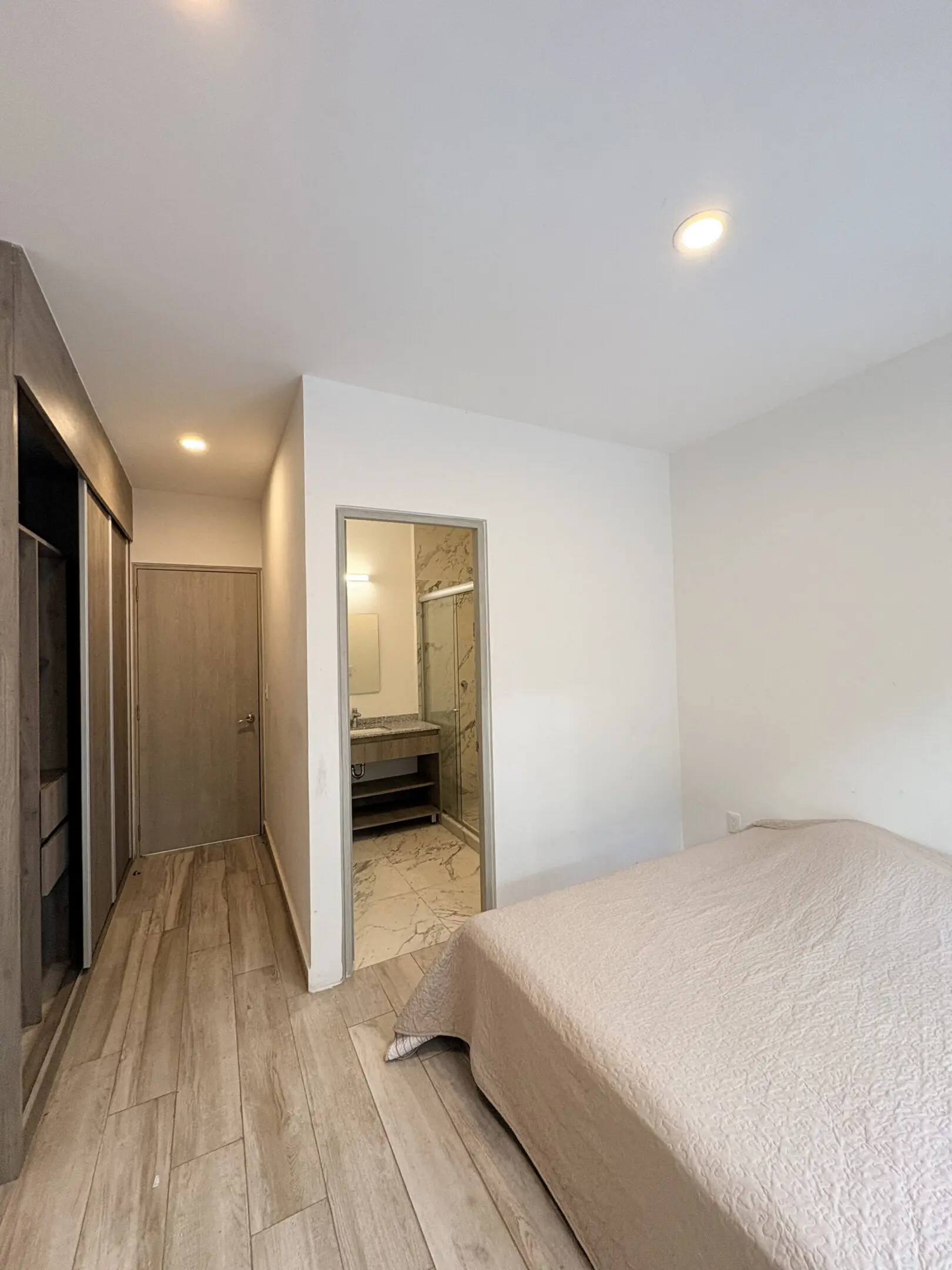 Minimalist bedroom with ensuite bathroom and bed