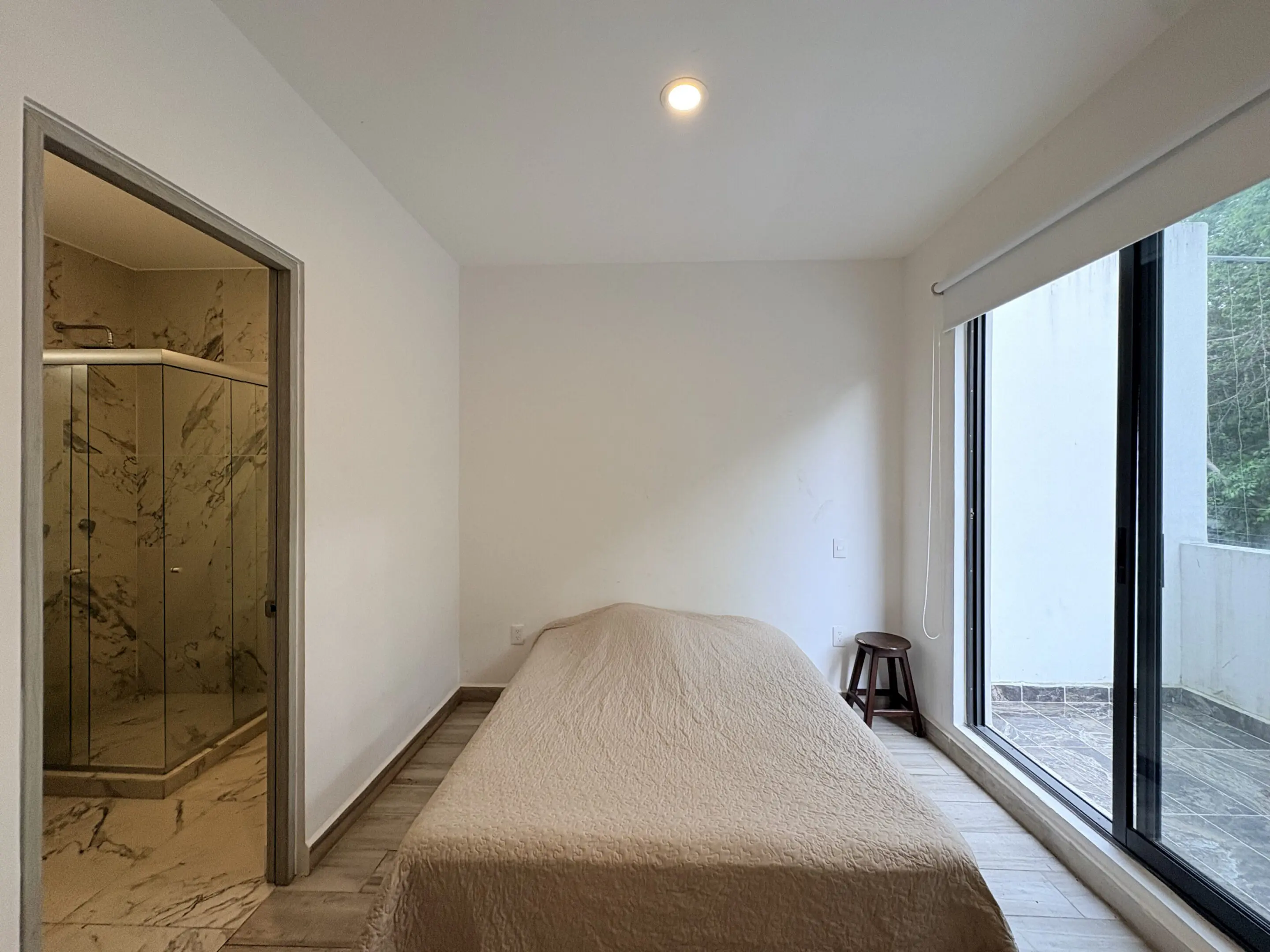 Minimalist bedroom with bed and marble shower