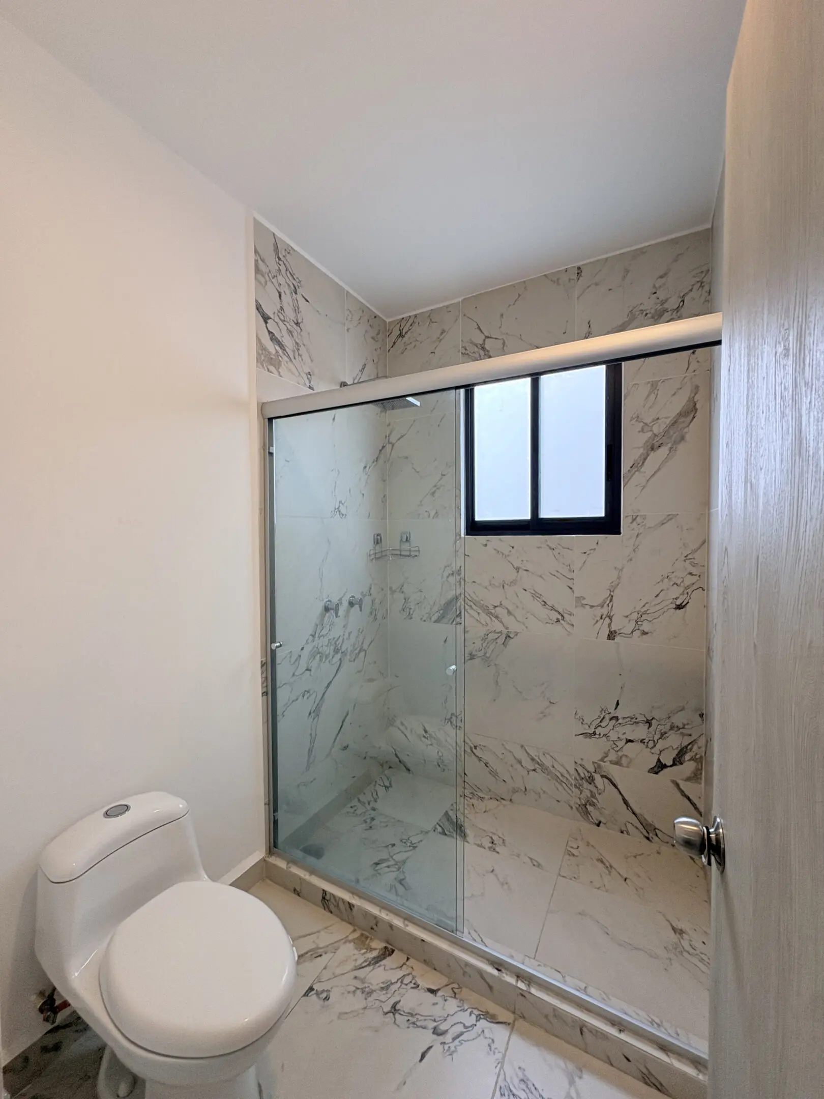 Marble-tiled bathroom with glass shower