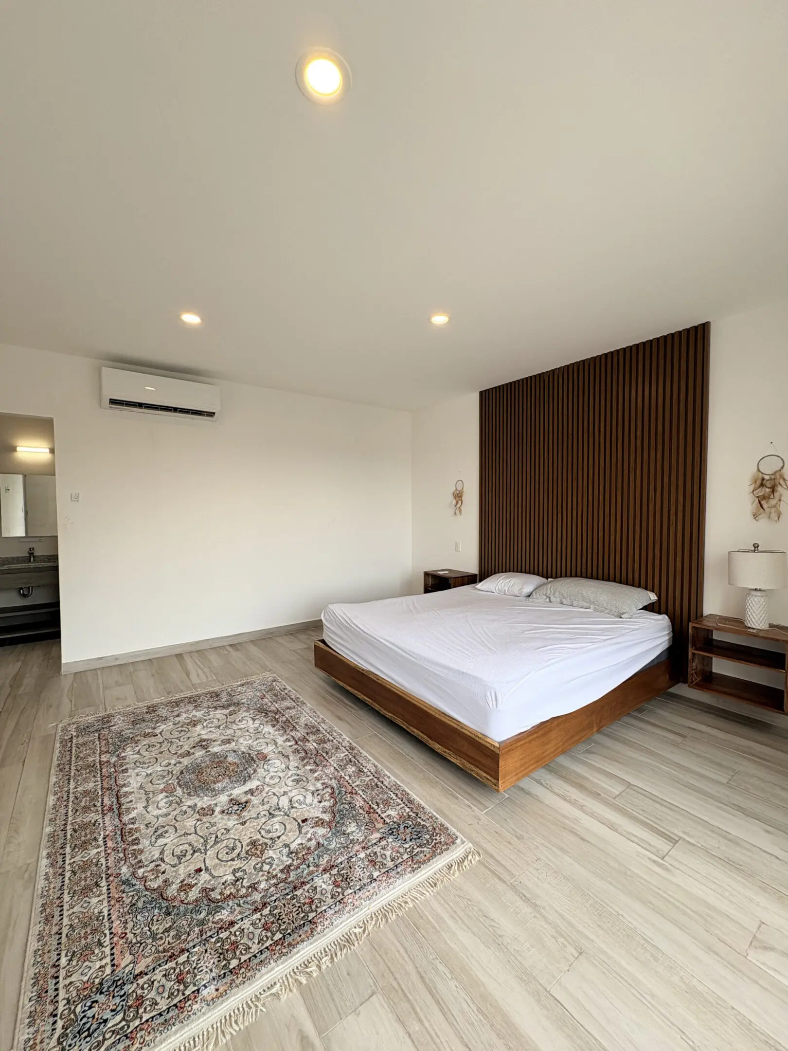 Minimalist bedroom with slatted wood accent wall