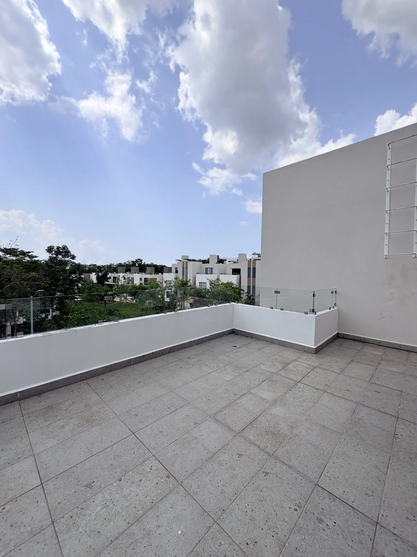 Empty rooftop terrace with cloudy blue sky