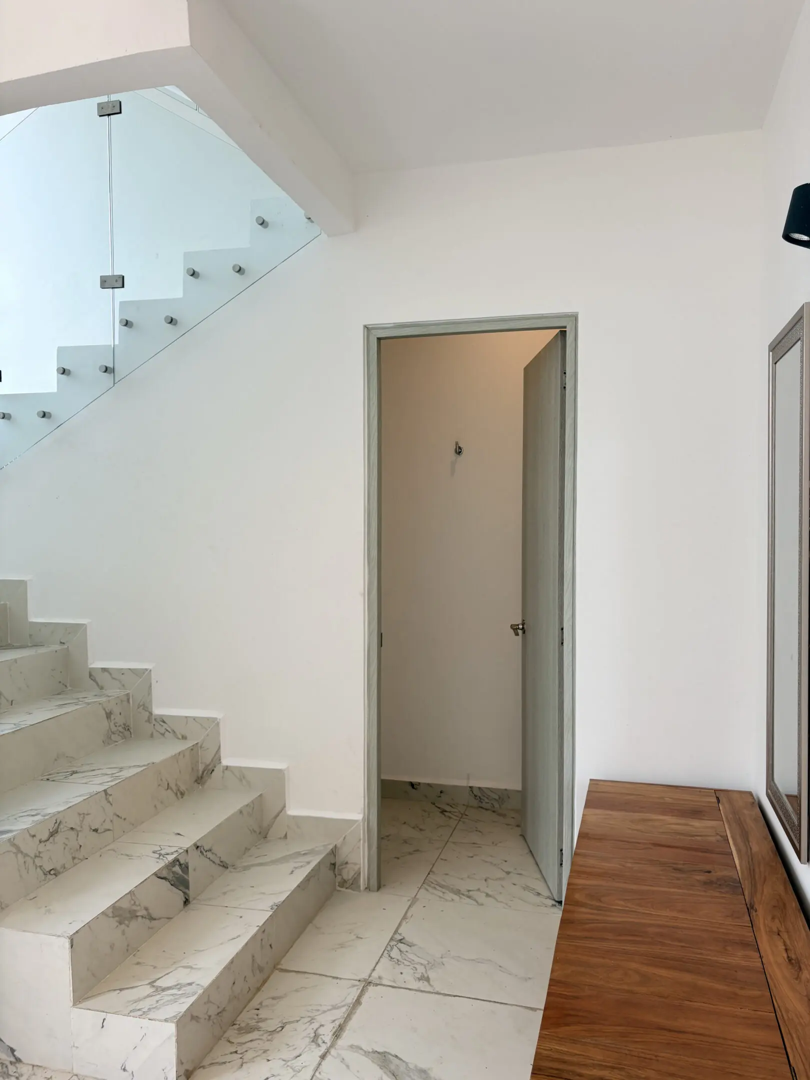 Marble staircase with glass railing and bench