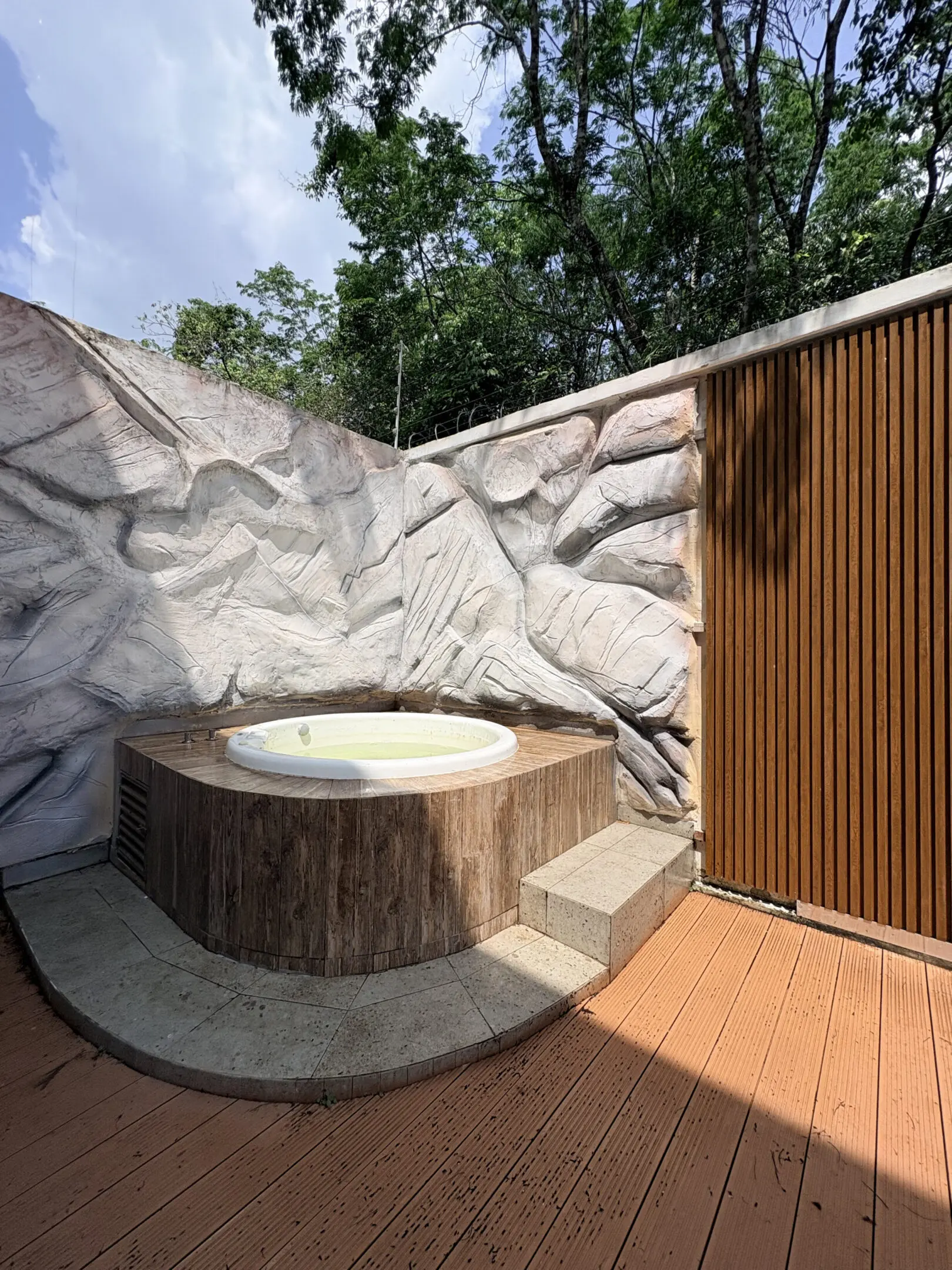 Outdoor round hot tub with rock wall