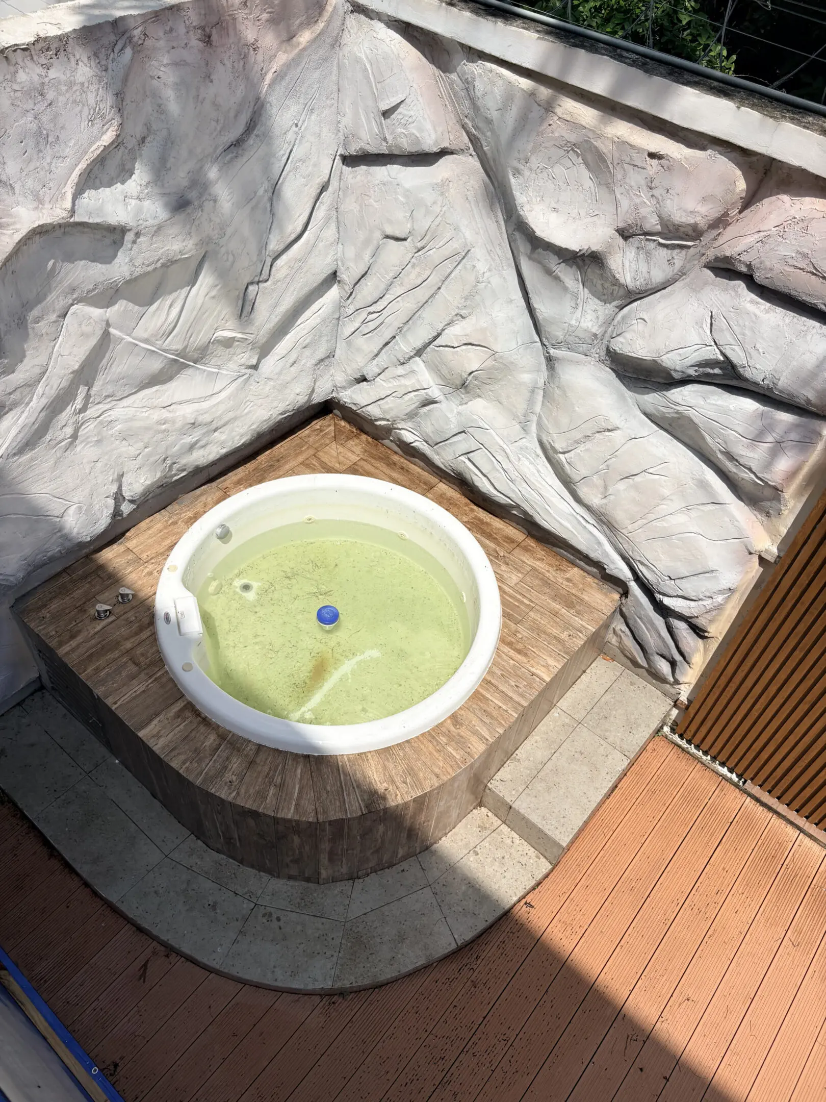 Round outdoor hot tub with green water