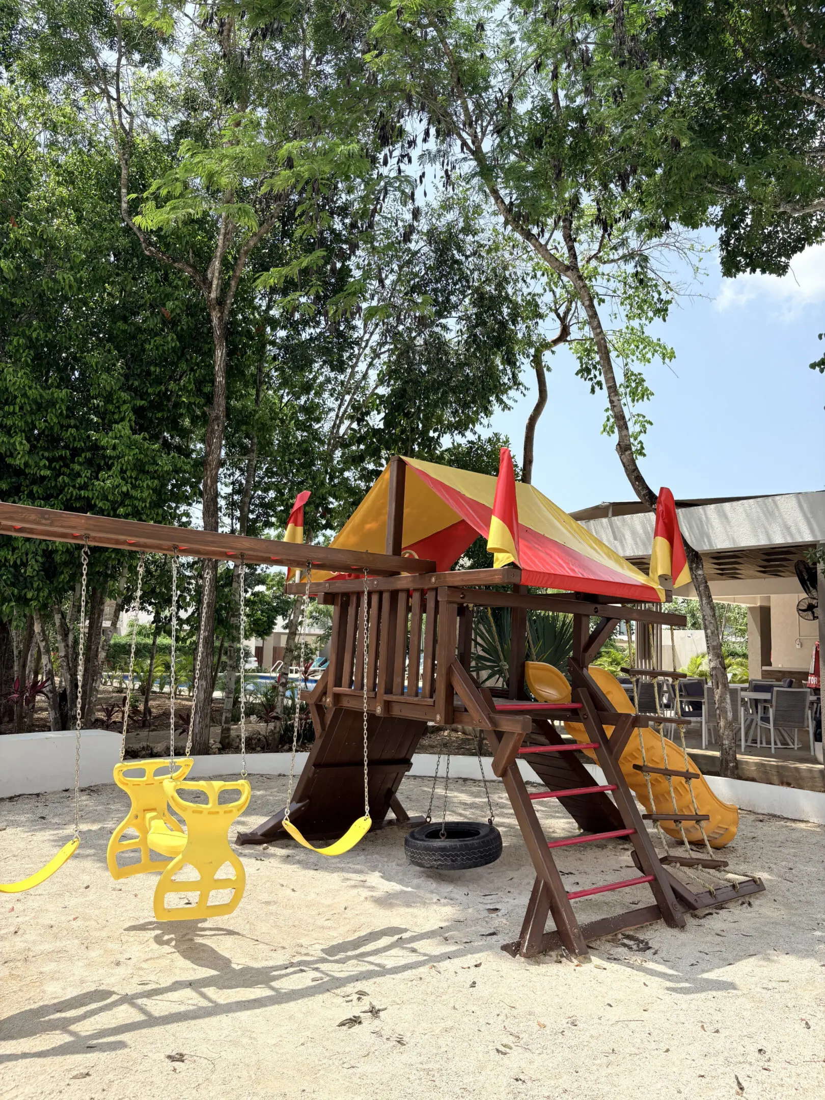 Colorful wooden playground with swings and slide