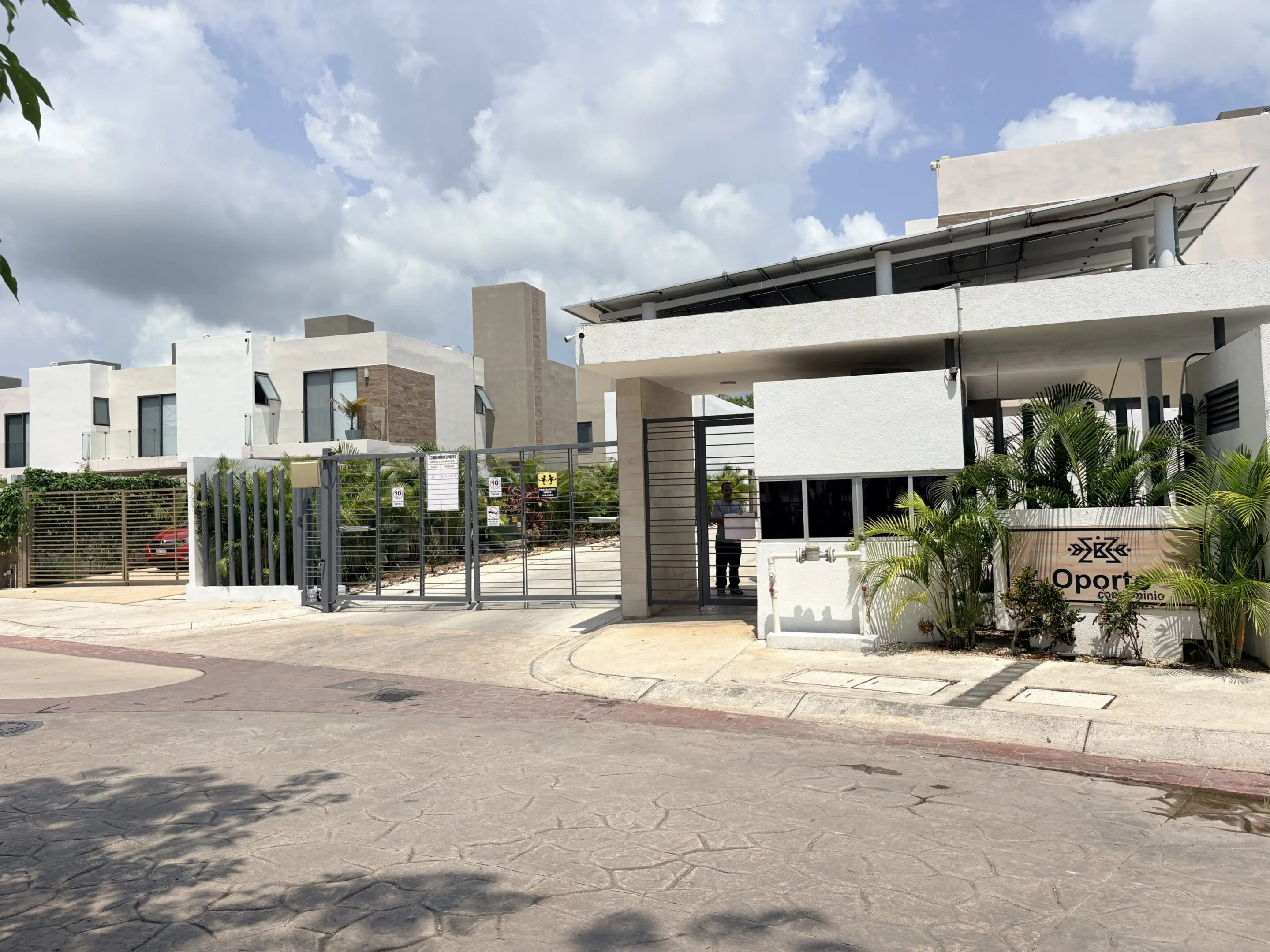 Gated modern residential complex entrance with sign