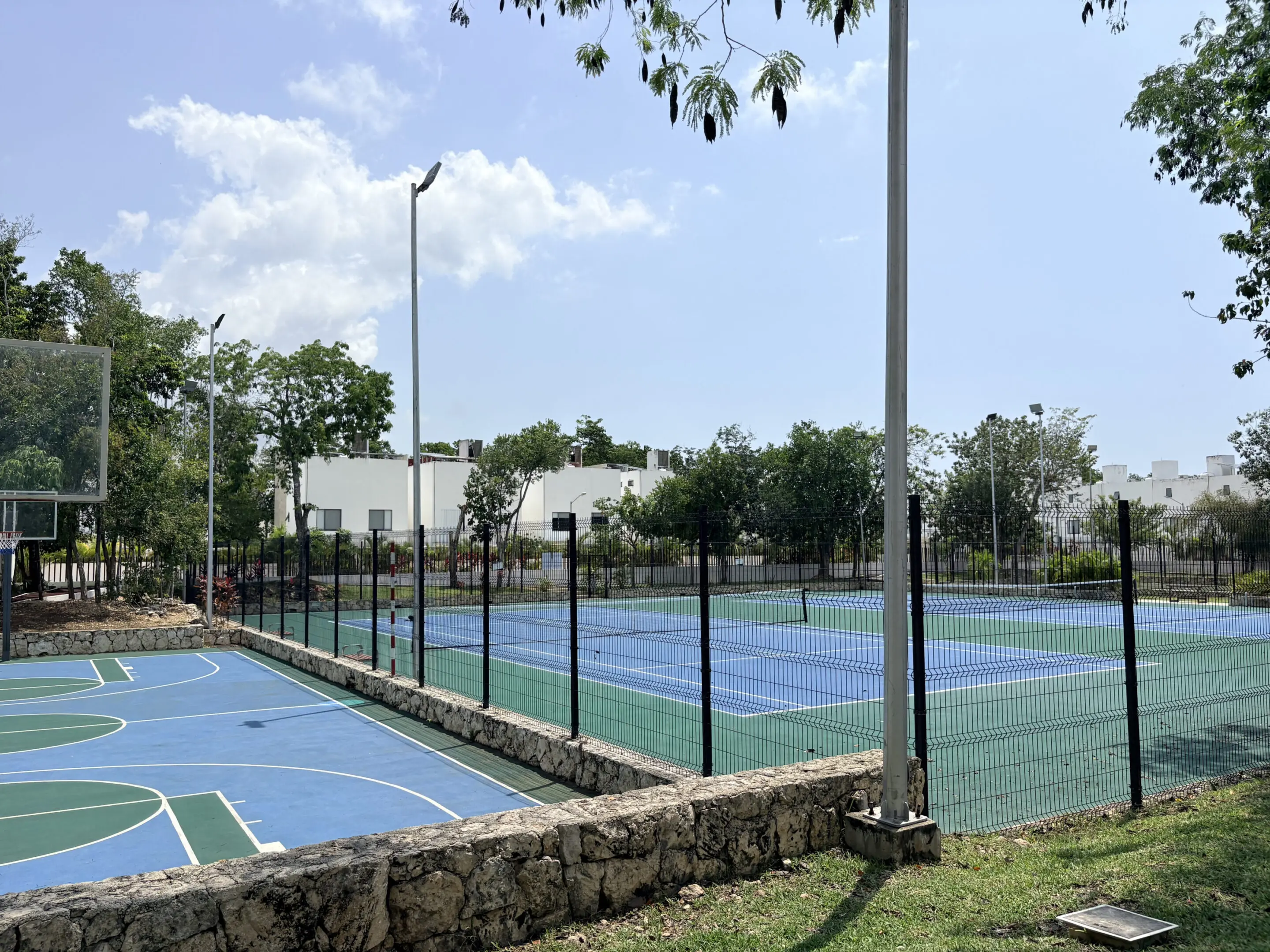 Fenced outdoor tennis and basketball courts