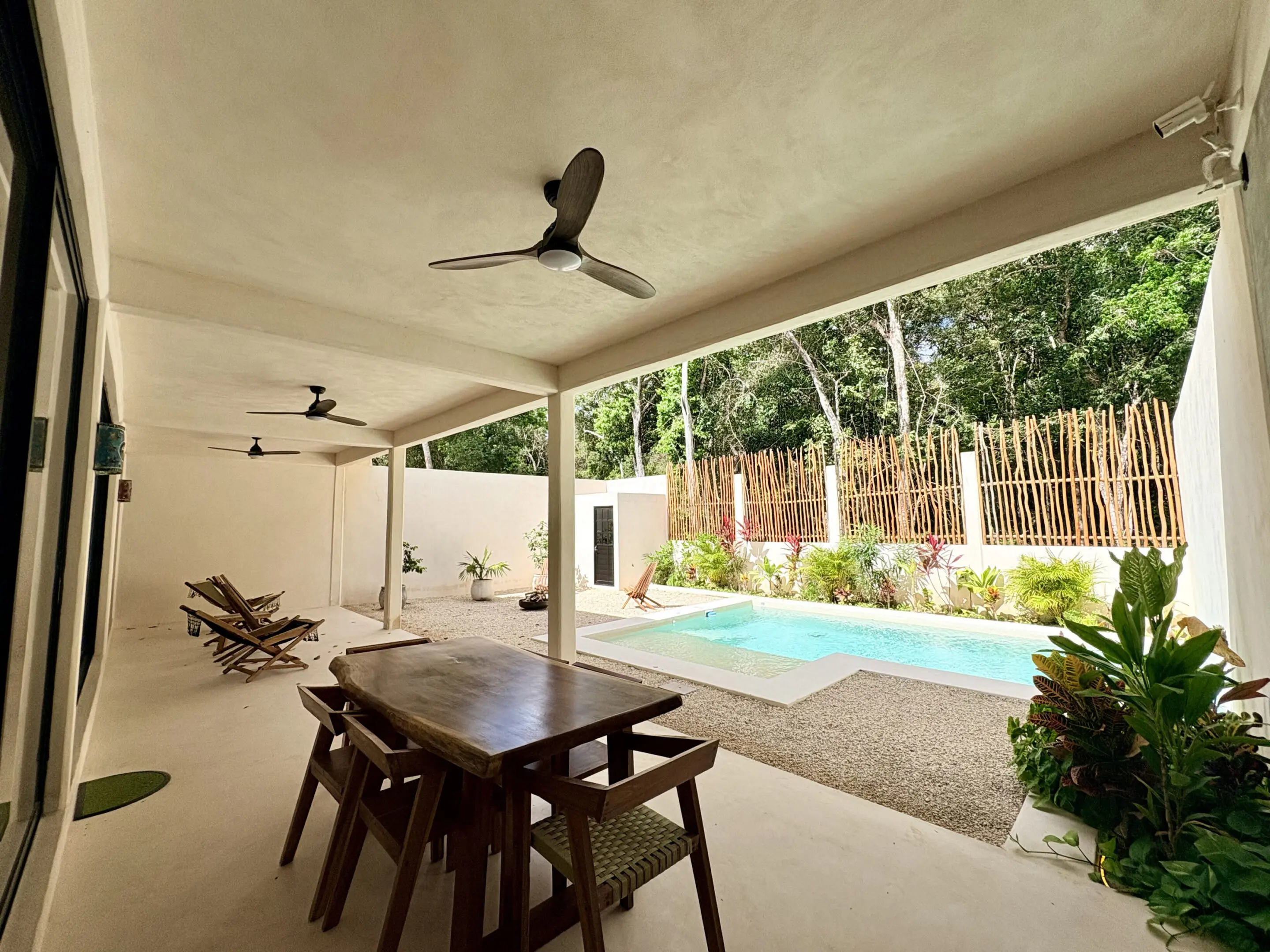 Covered patio with dining table and pool