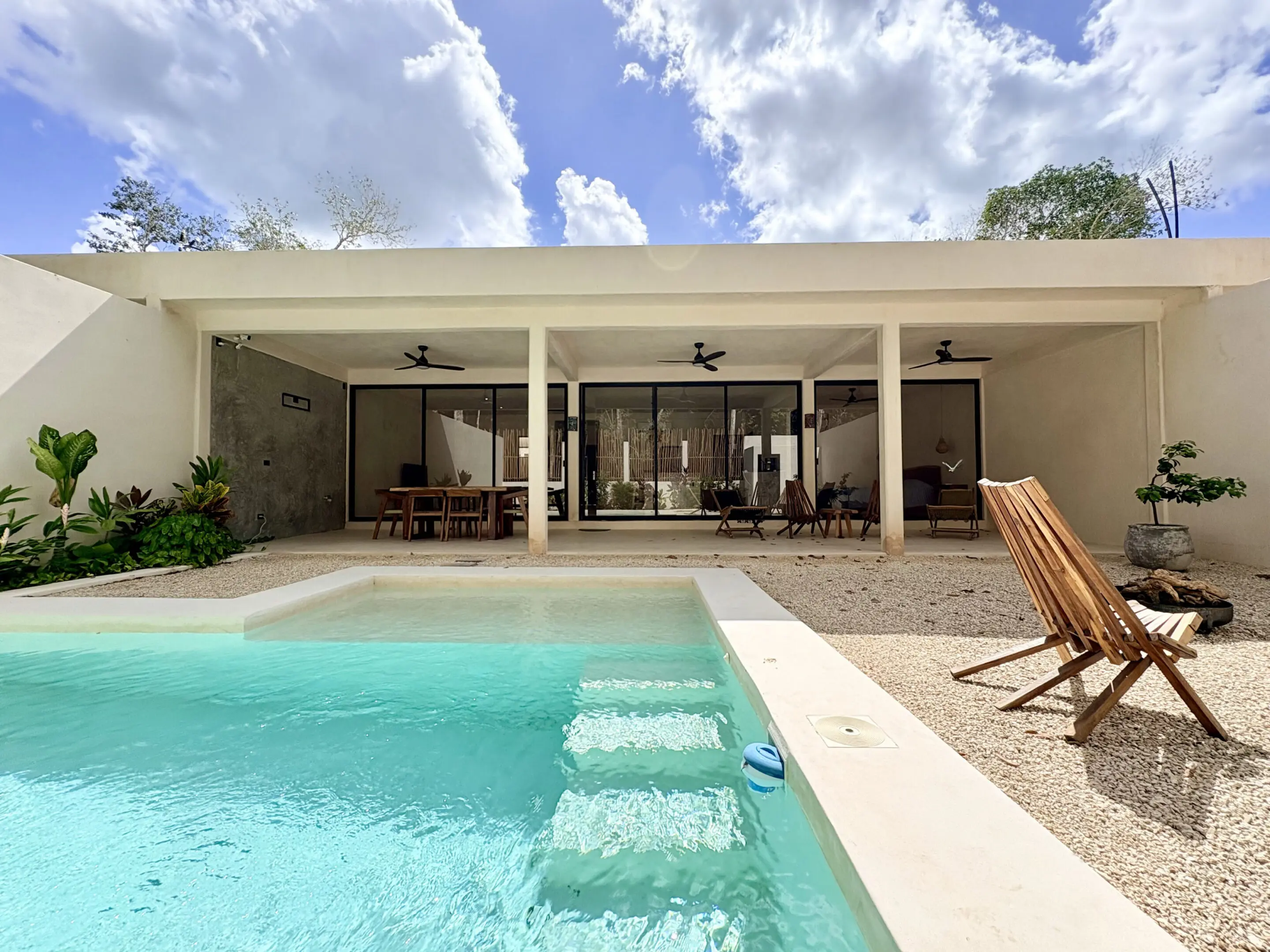 Modern patio with pool and wooden chairs