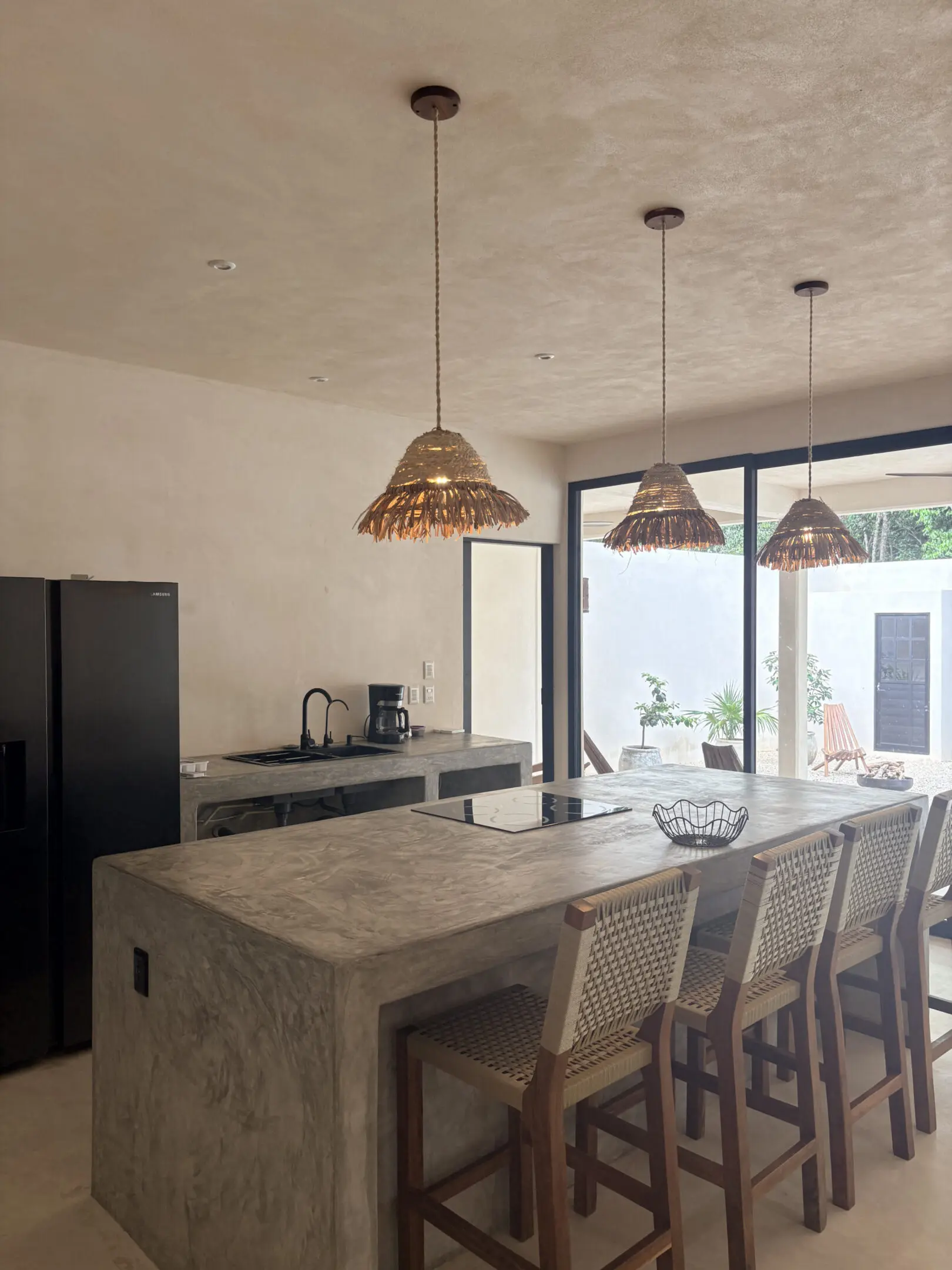 Modern kitchen with concrete island and pendants