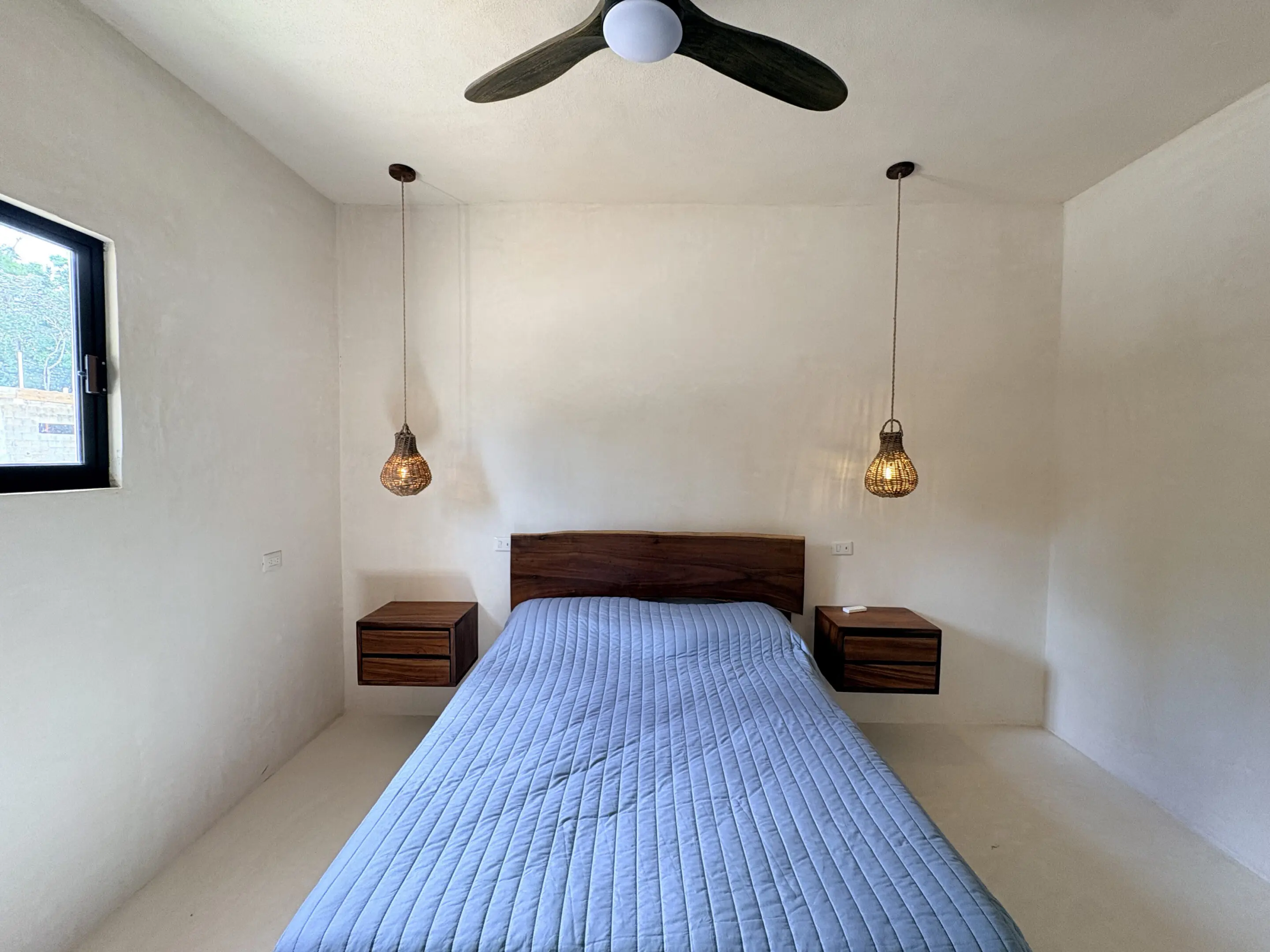 Minimalist bedroom with blue quilted bed