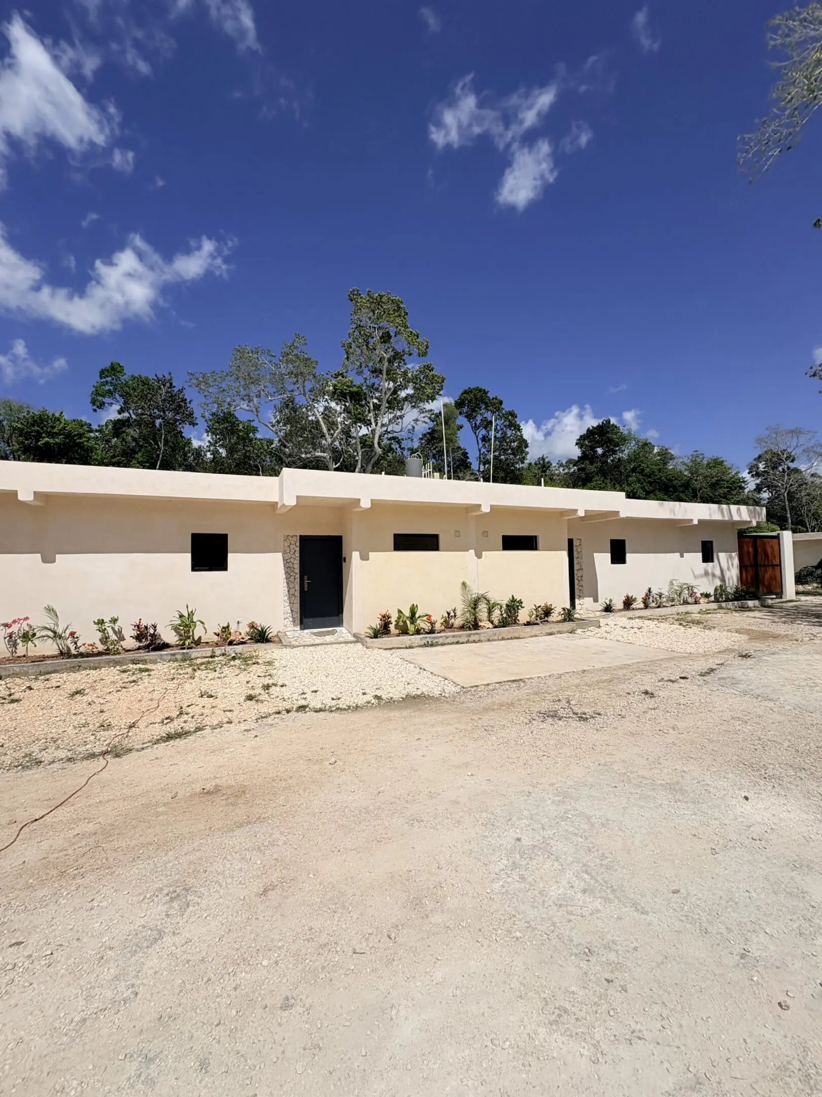 Row of beige single-story units under blue sky