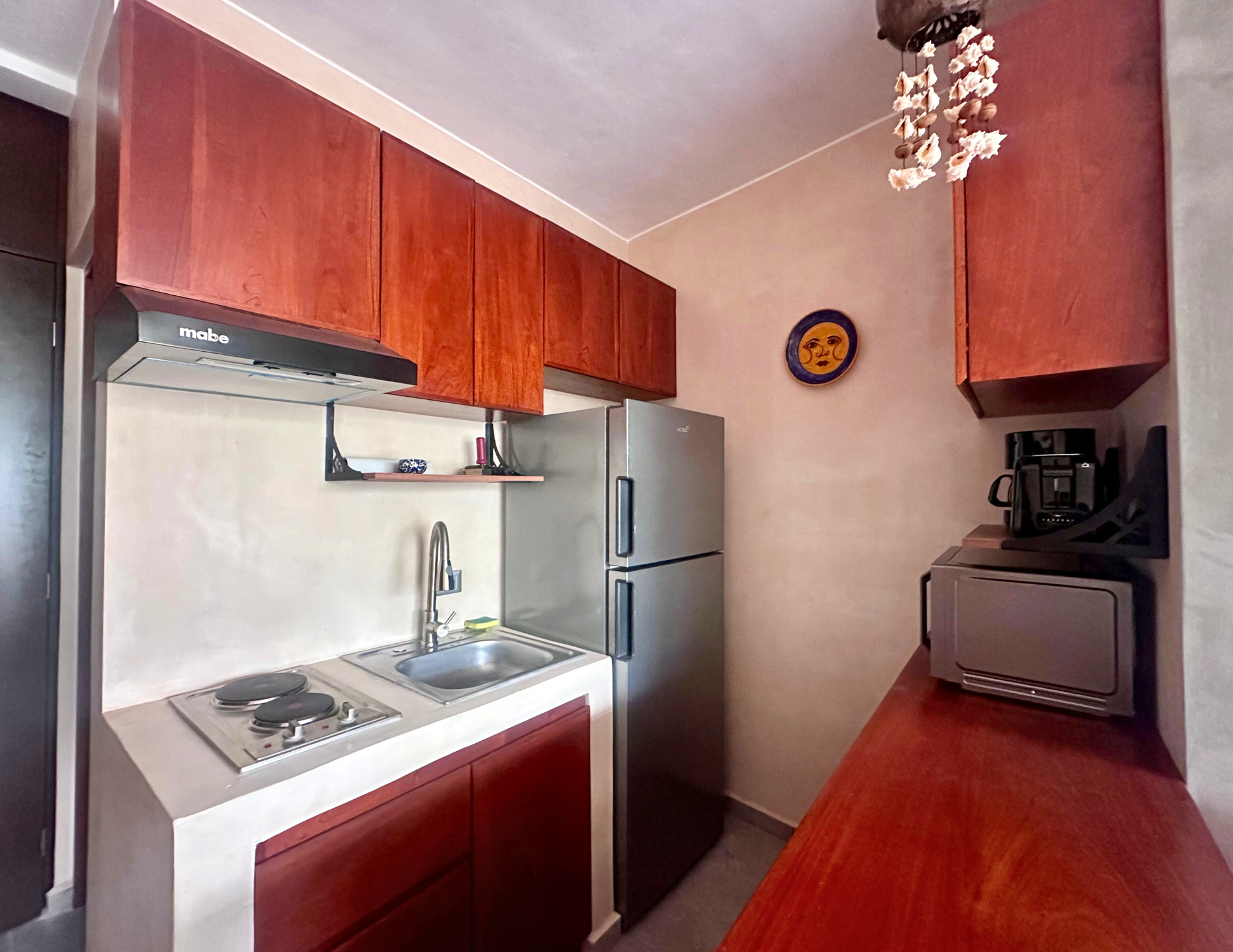 Compact kitchen with wooden cabinets and appliances