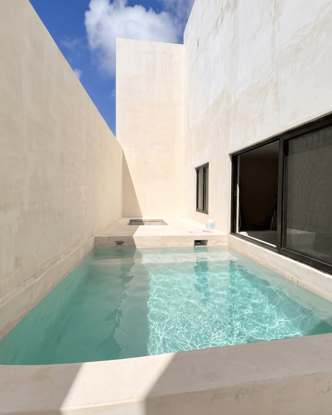 Modern narrow courtyard pool with turquoise water