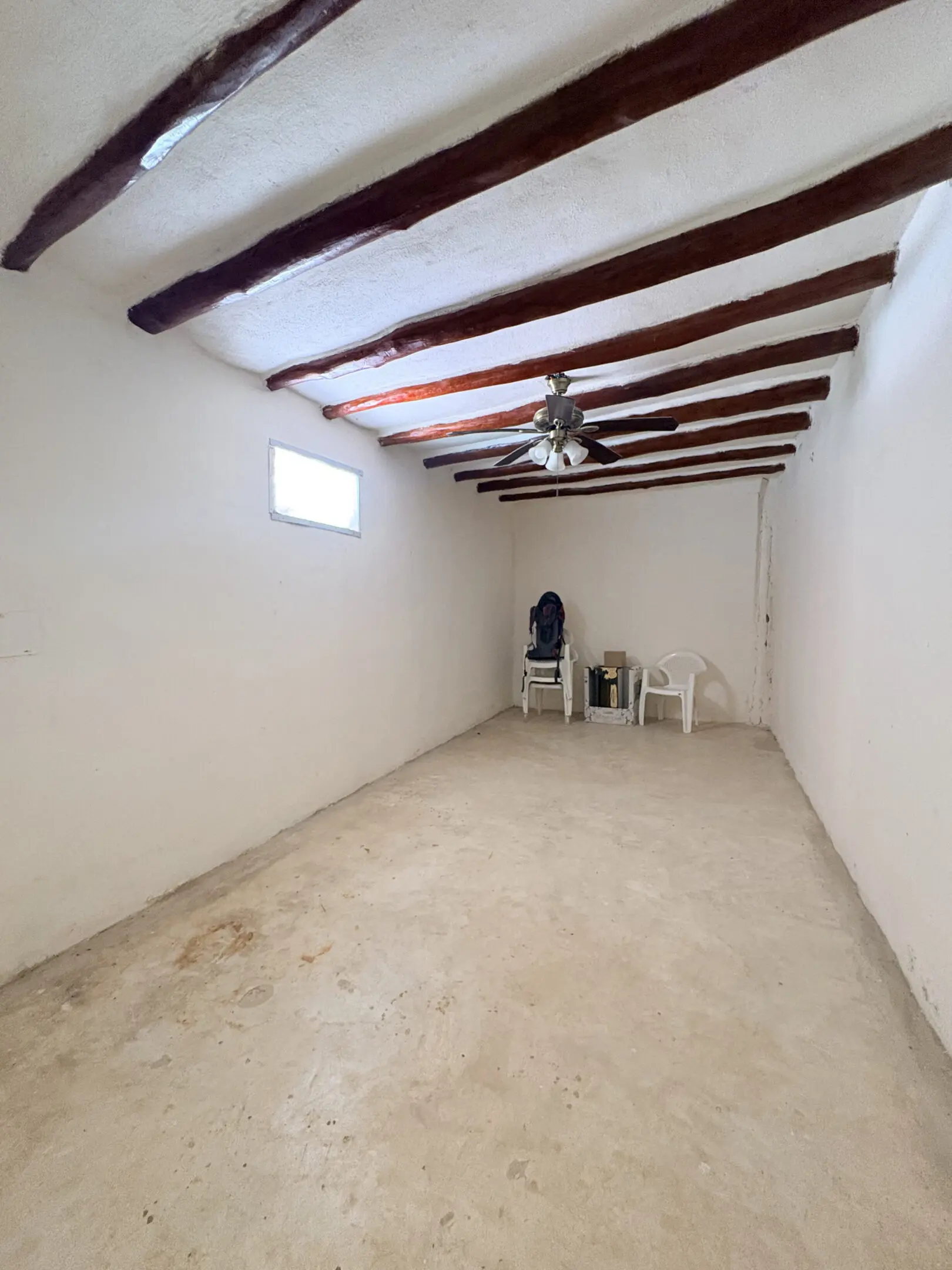 Empty narrow interior room with exposed beams
