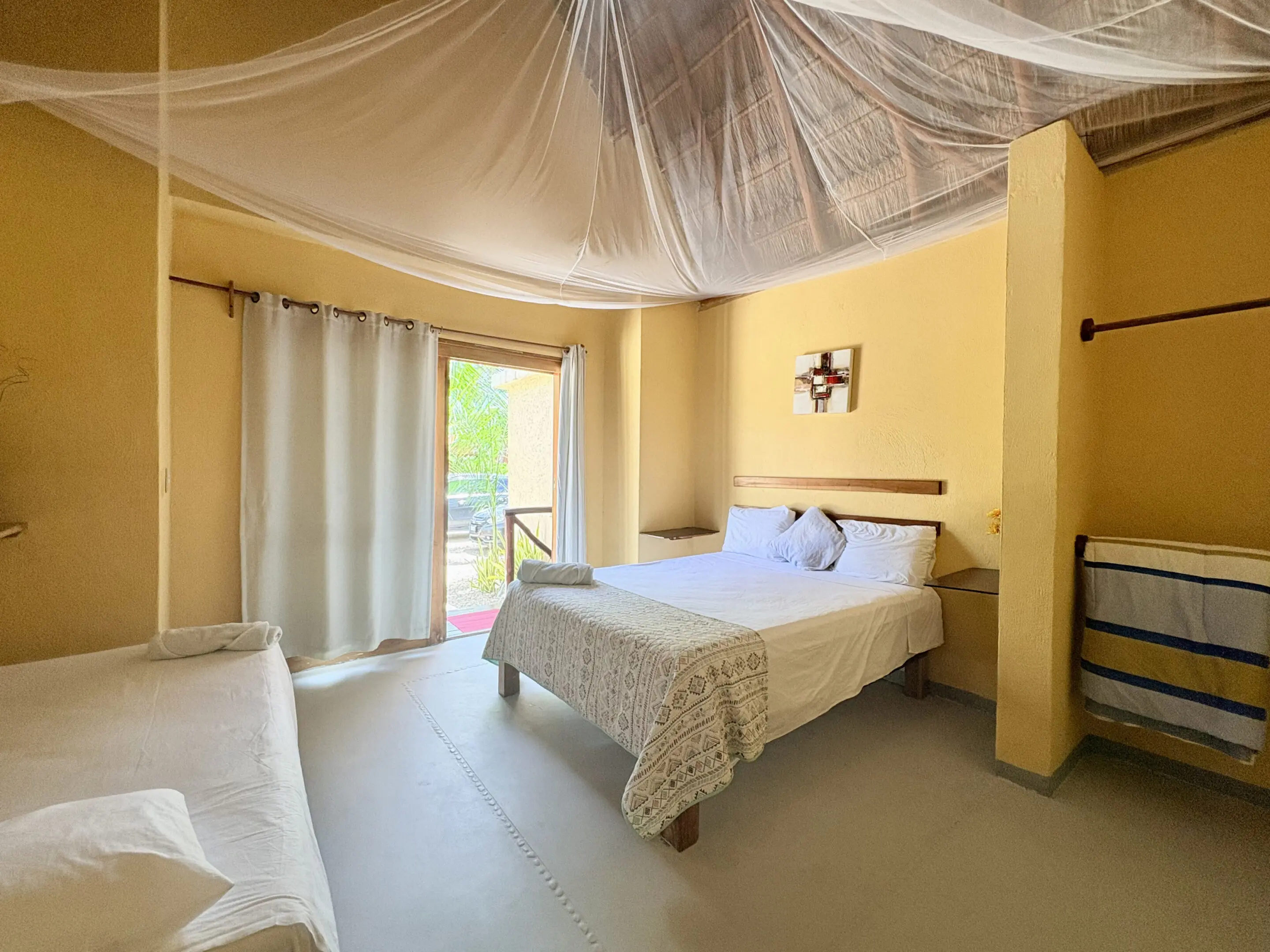 Bedroom with mosquito net canopy and balcony