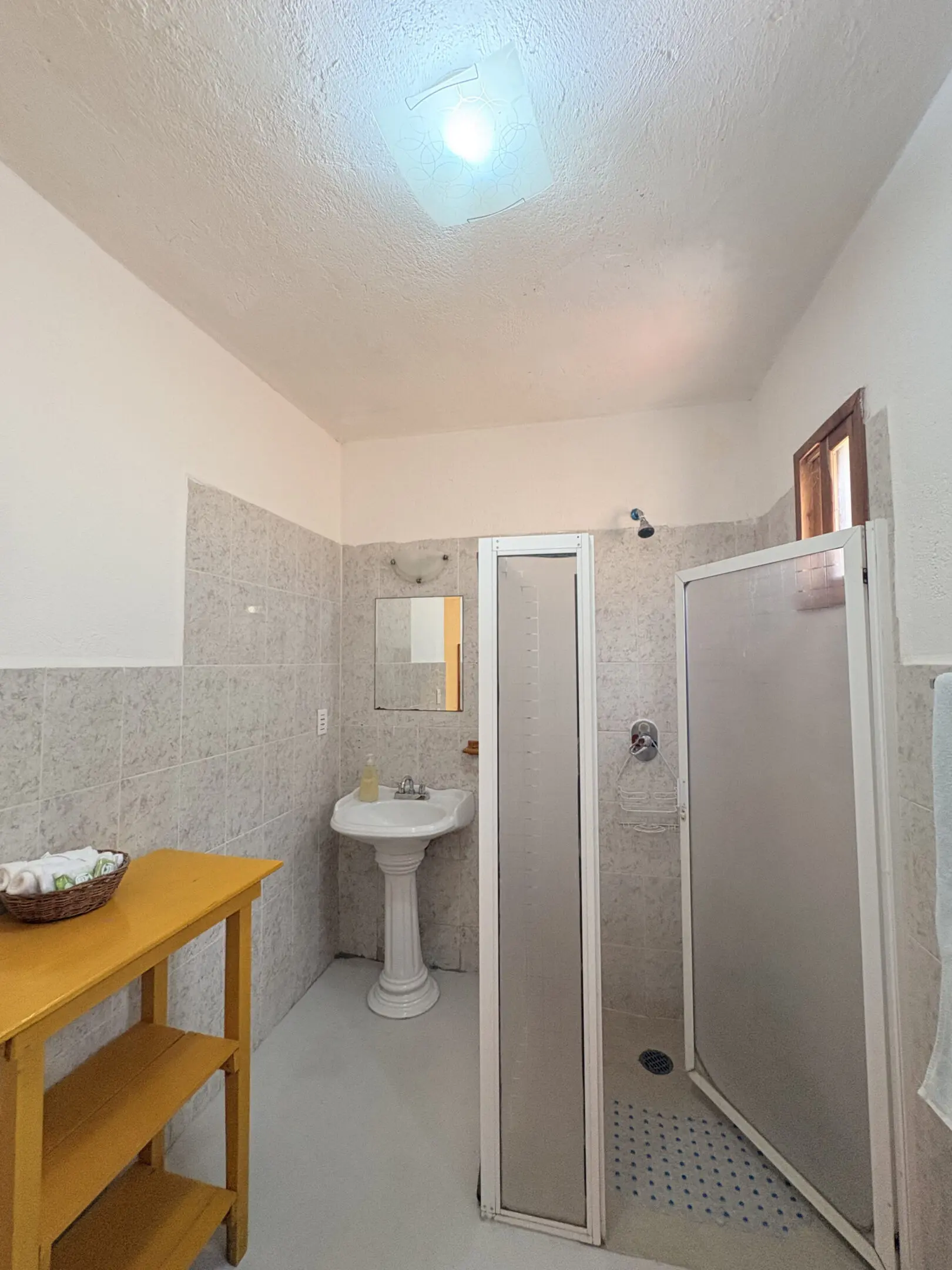 Small tiled bathroom with shower and sink
