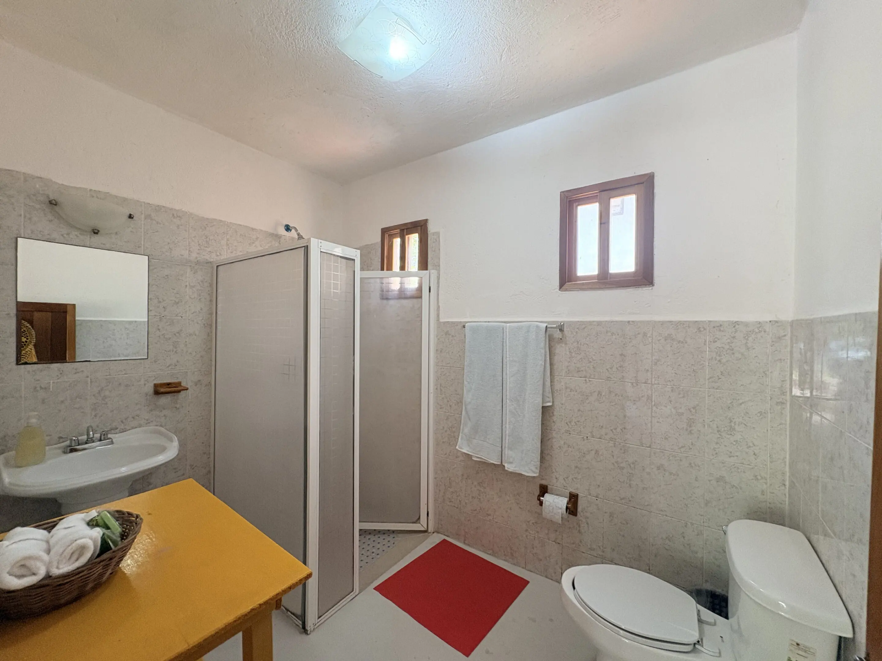 Tiled bathroom with shower, sink, and toilet