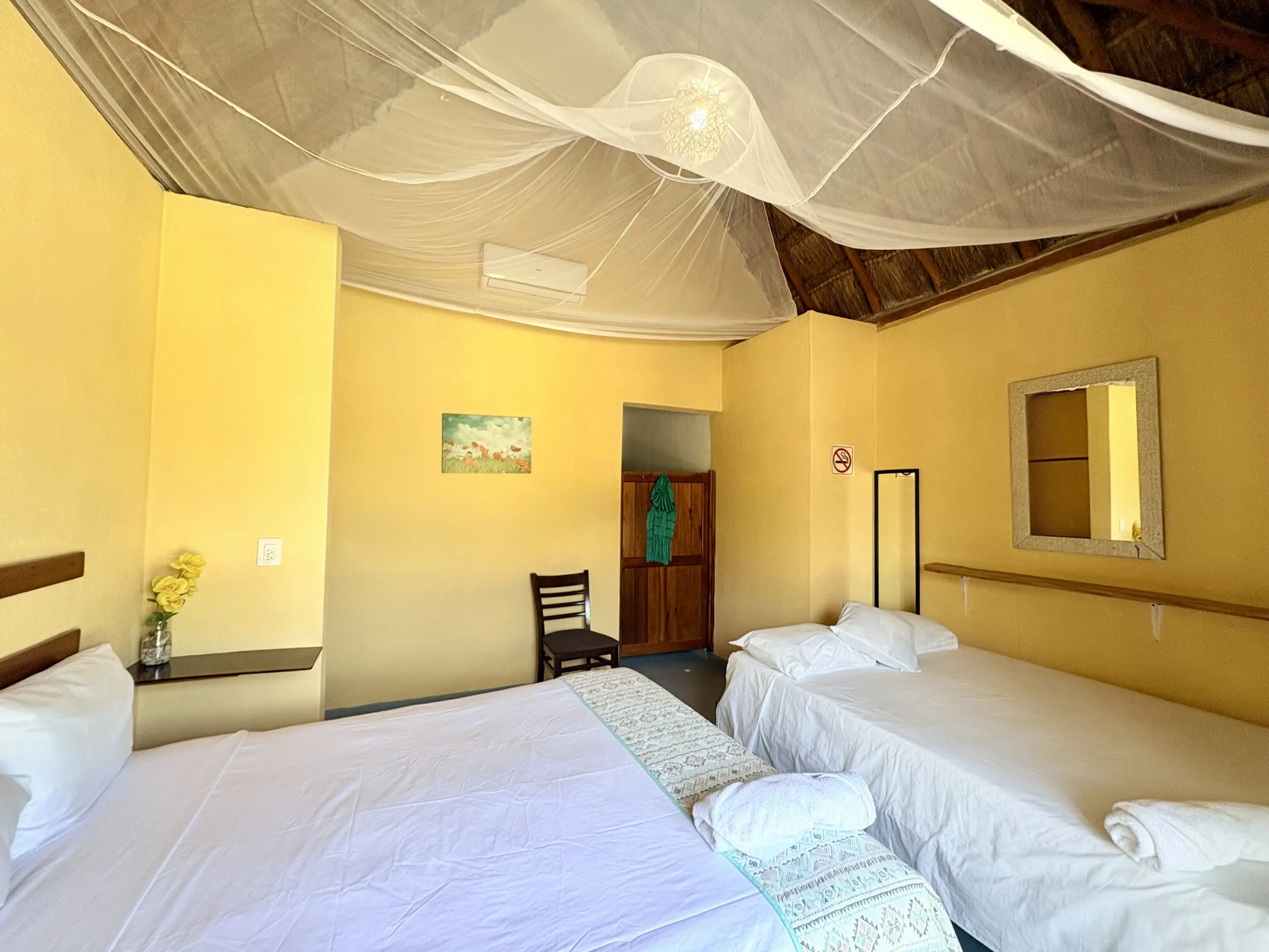 Room with mosquito net and two beds