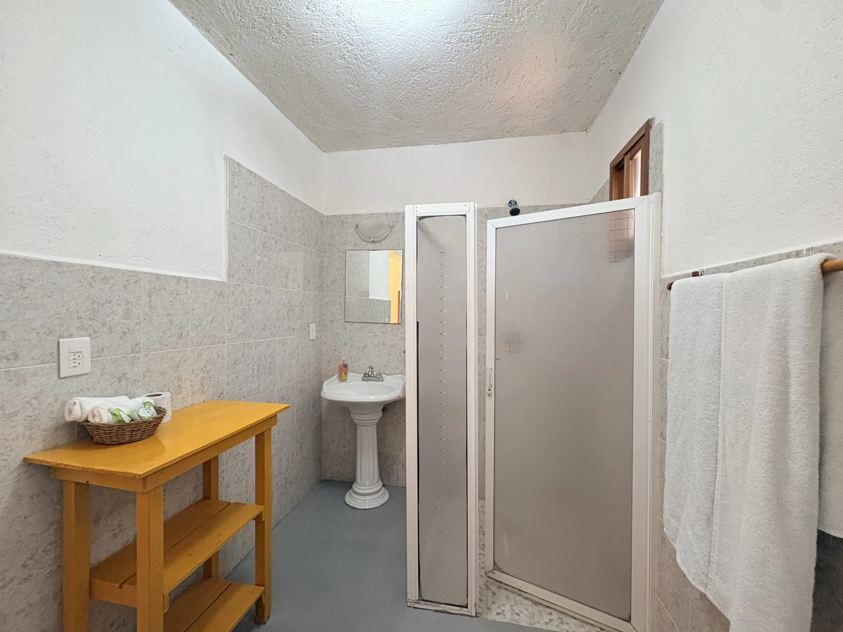 Small bathroom with shower and pedestal sink