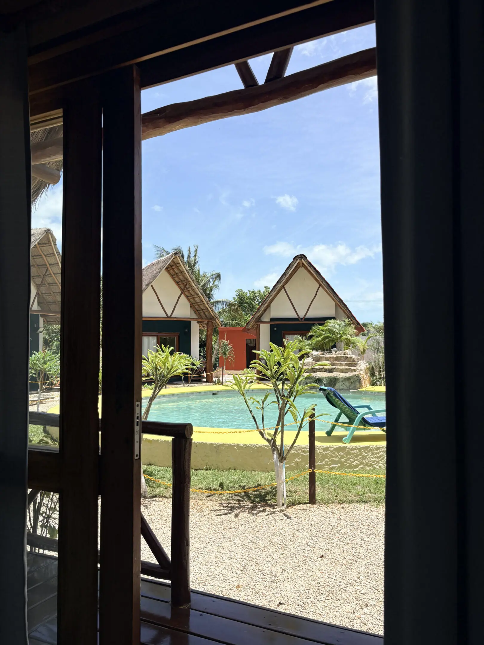 Tropical resort pool with thatched bungalows