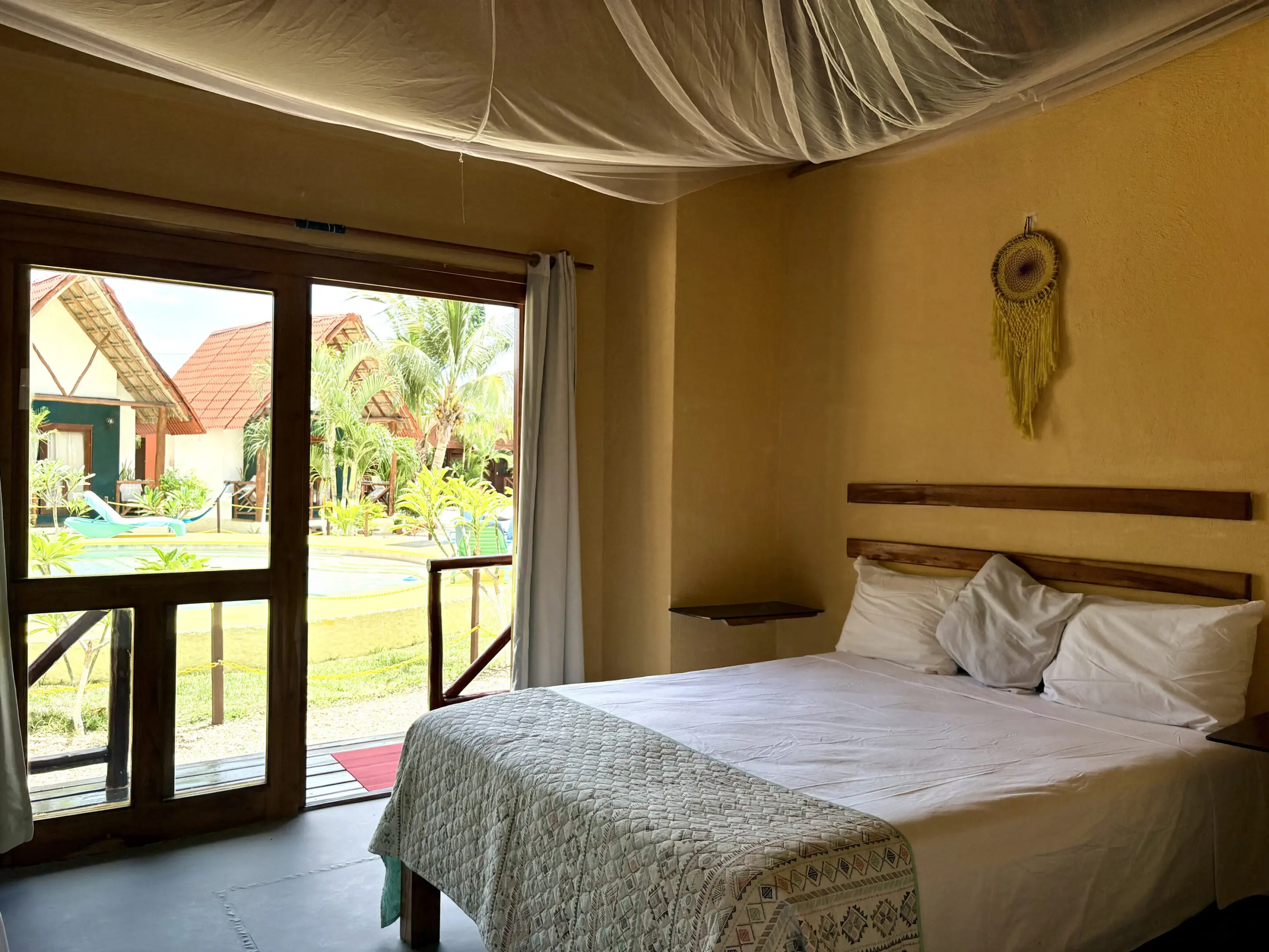 Tropical bedroom with bed, mosquito net, balcony