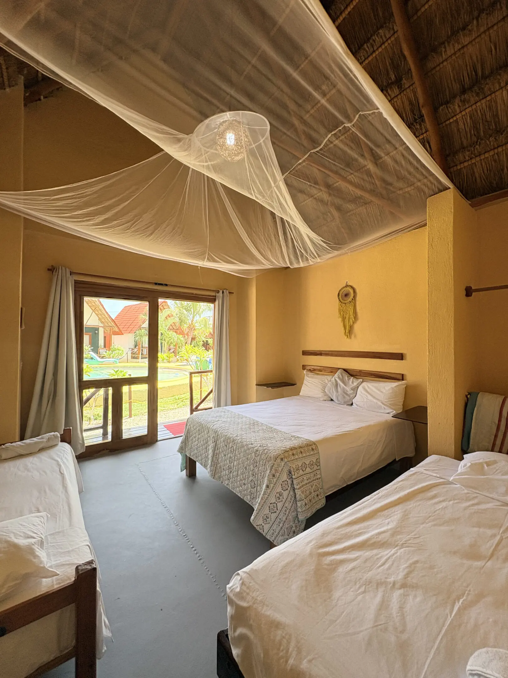 Tropical bungalow bedroom with beds and mosquito net