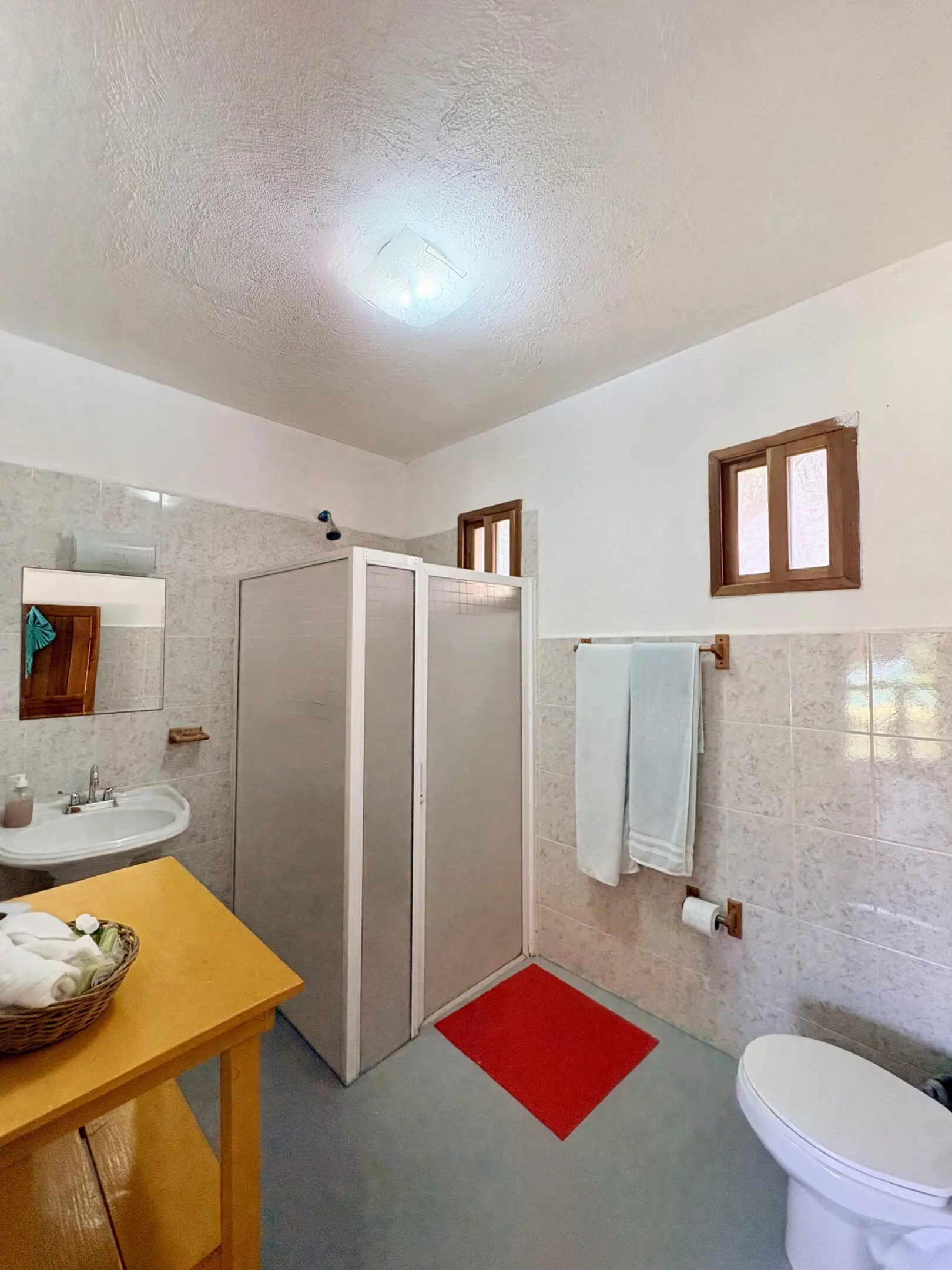 Small bathroom with shower stall, sink, toilet
