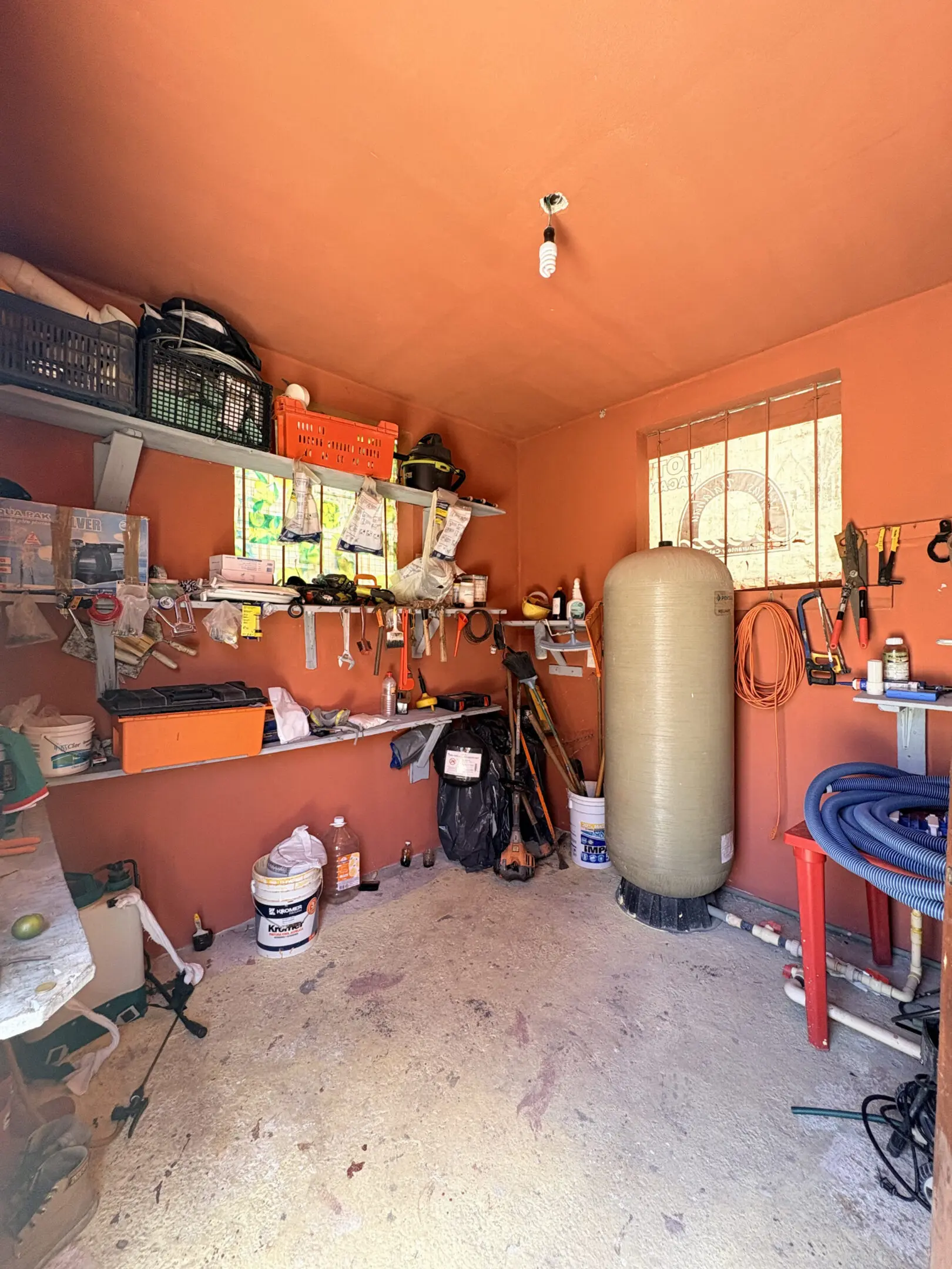 Orange-walled workshop with tools and tank