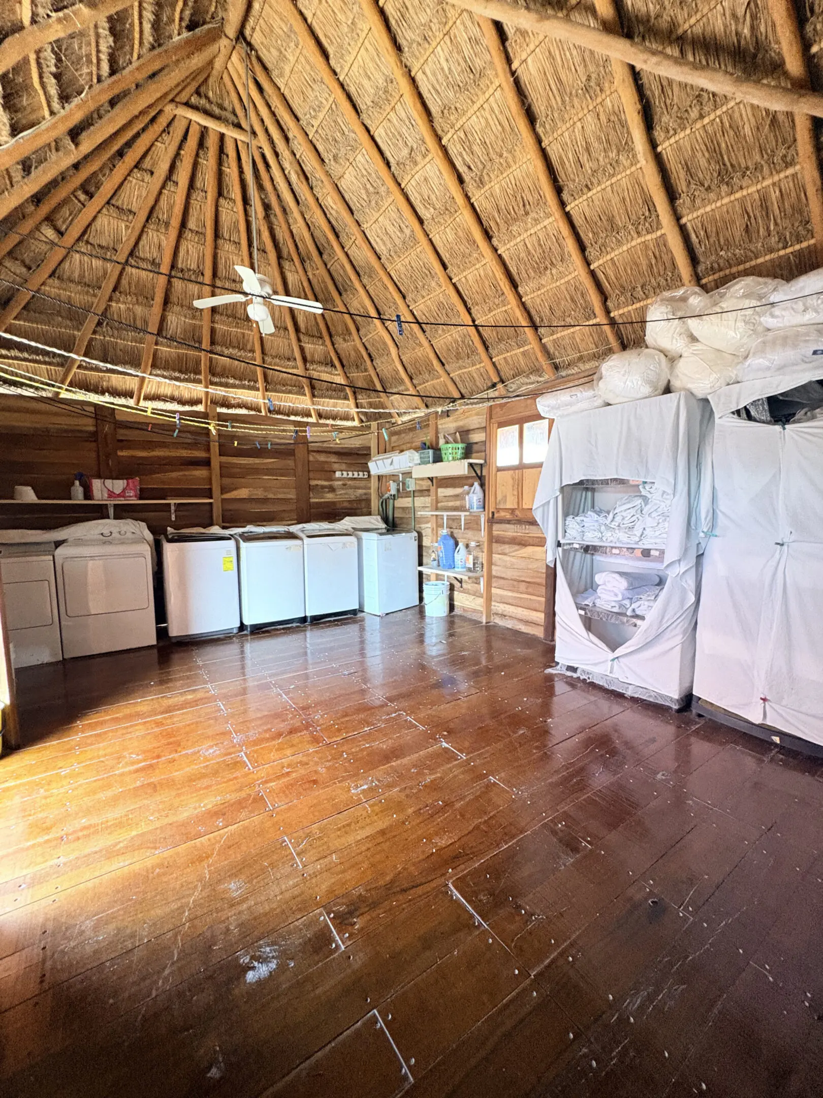 Thatched-roof laundry room with washers and dryers