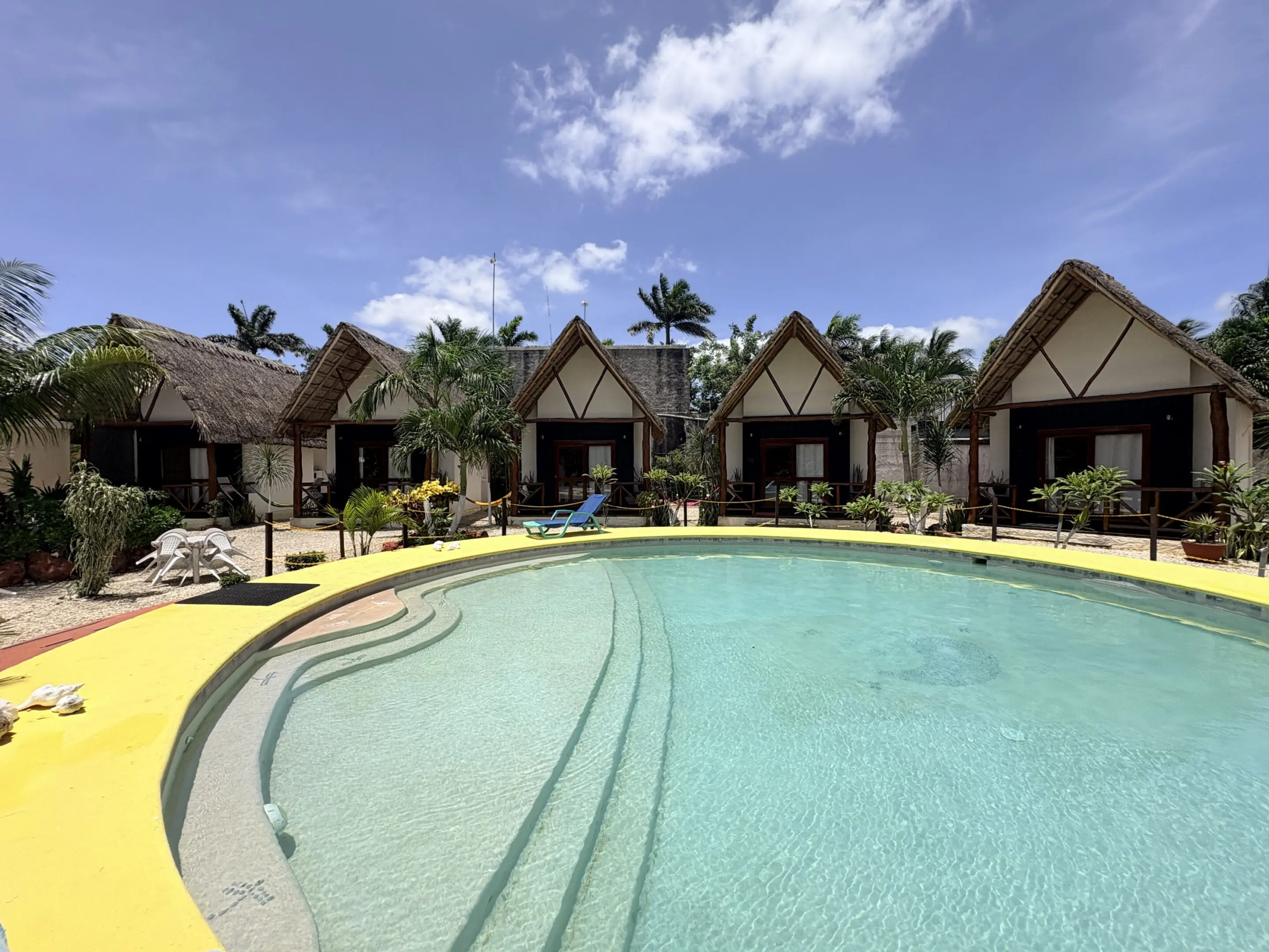 Thatched-roof bungalows around circular swimming pool