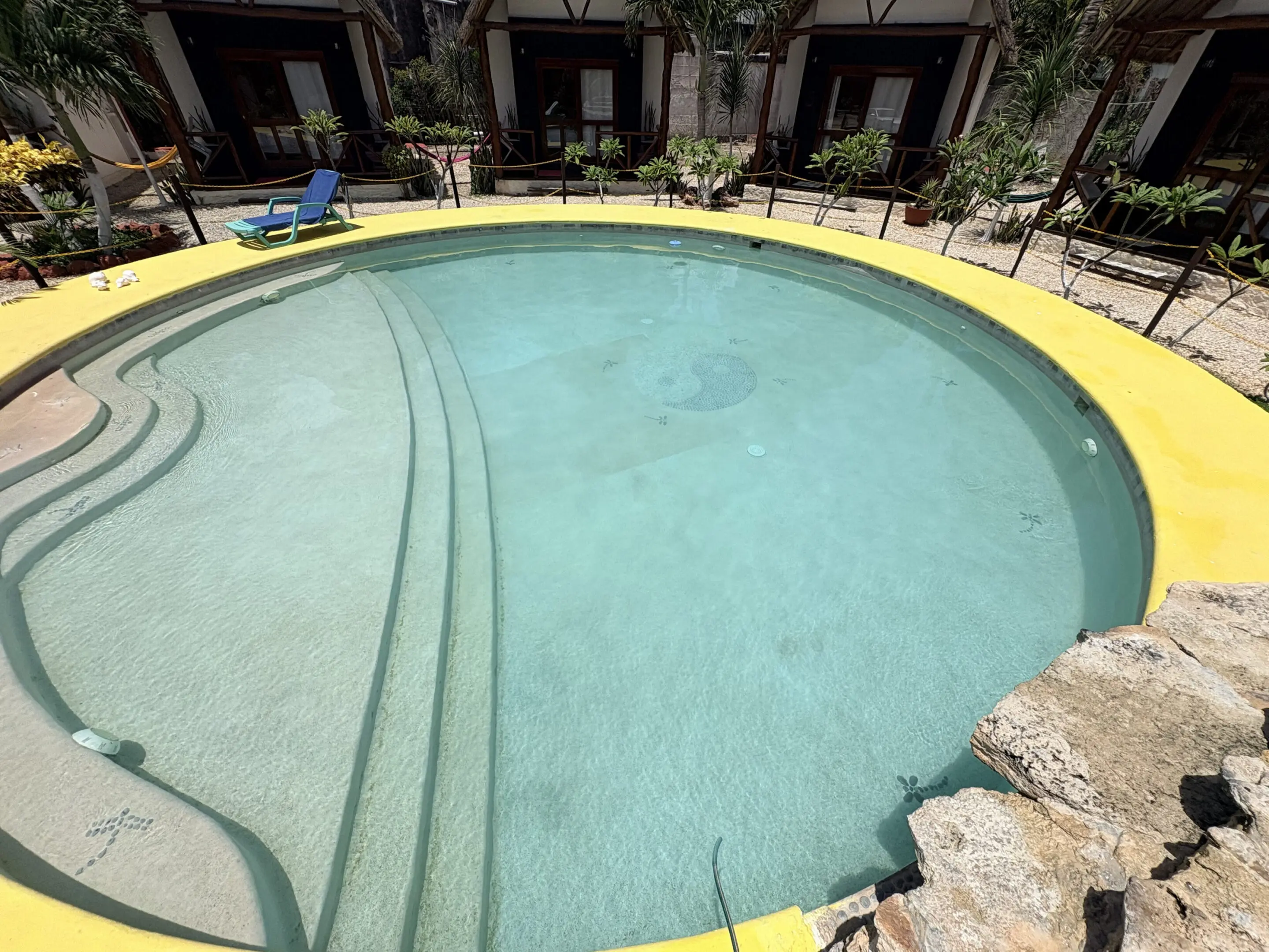 Round resort pool with yellow rim and steps