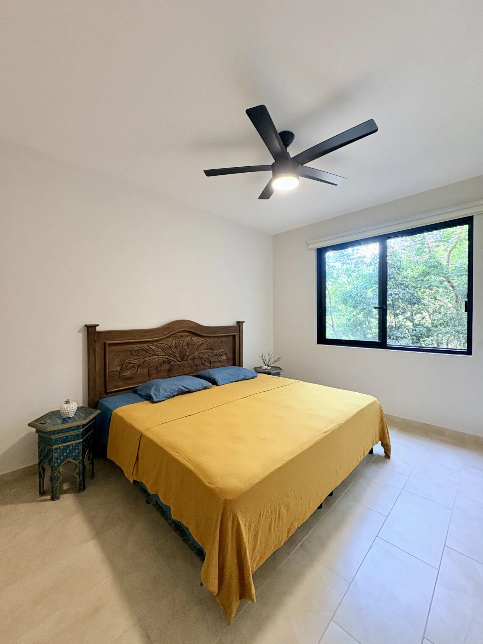 Bedroom with yellow bedspread and ceiling fan