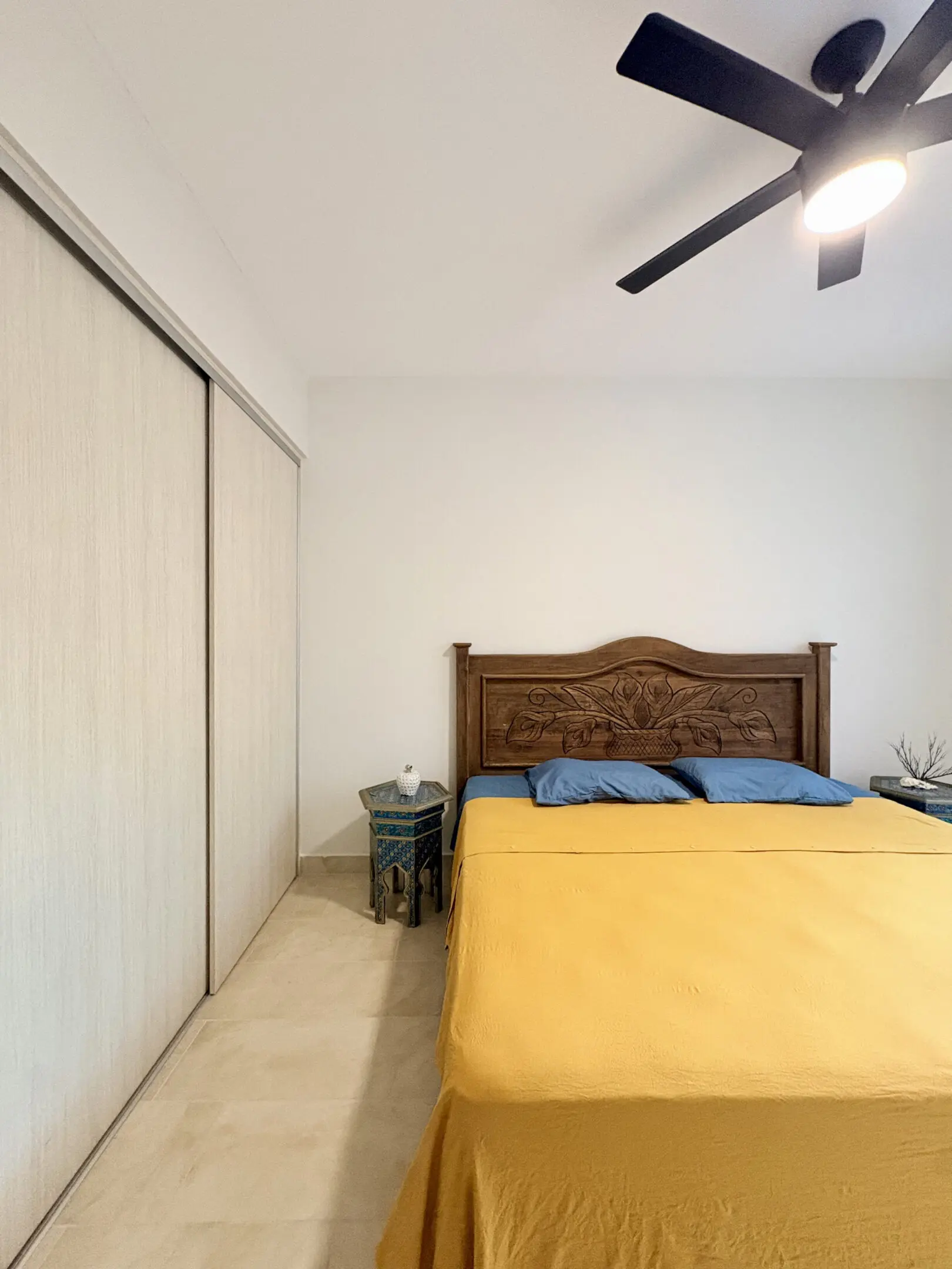 Bedroom with carved headboard and yellow bedspread