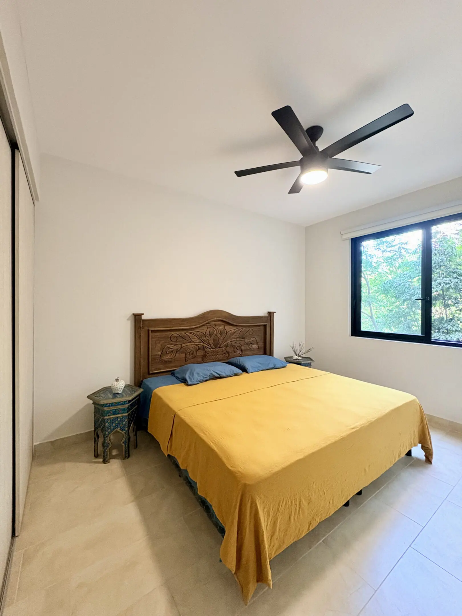 Bedroom with yellow bedspread and wooden headboard