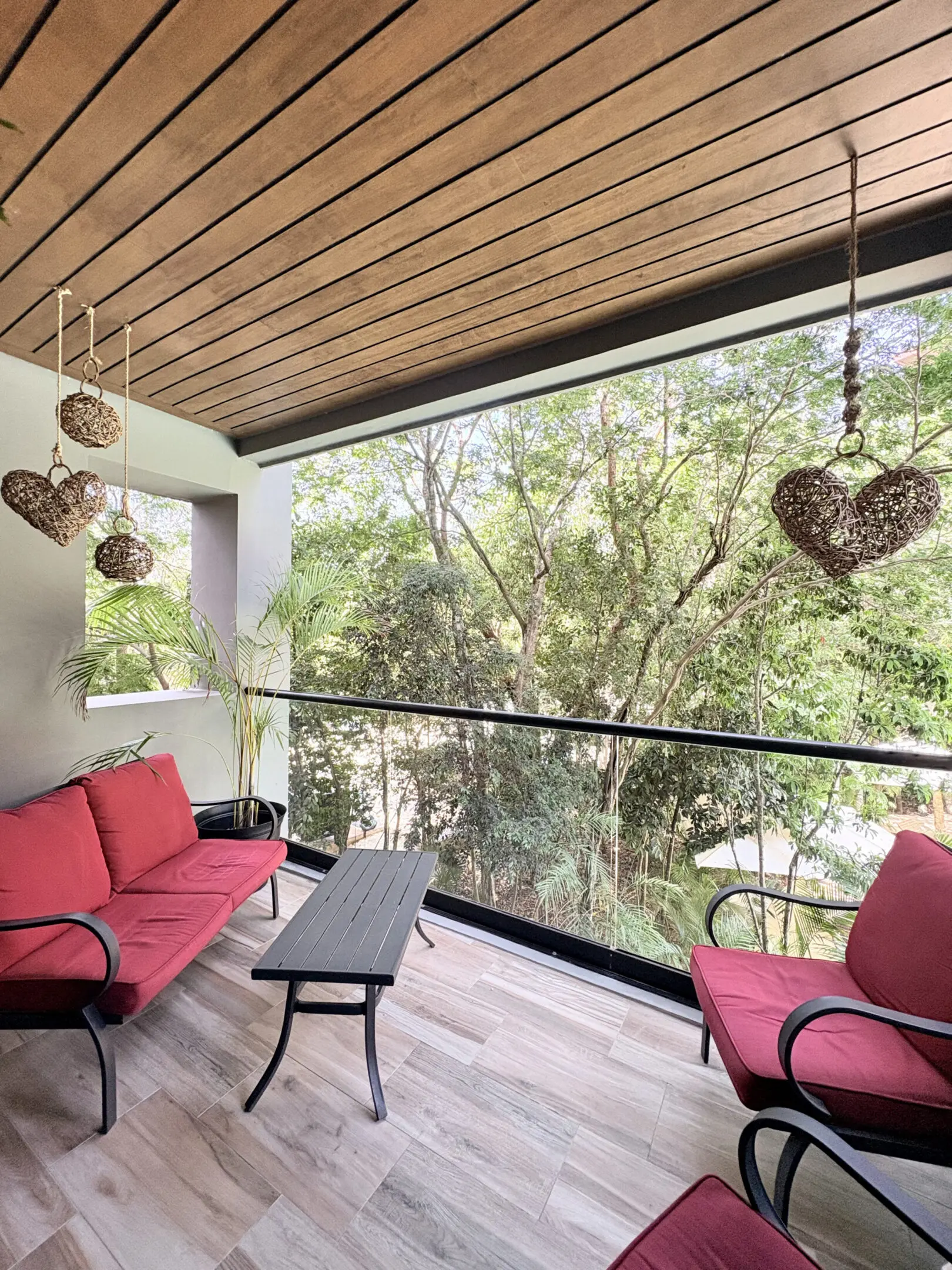 Balcony with red cushions and hanging wicker hearts
