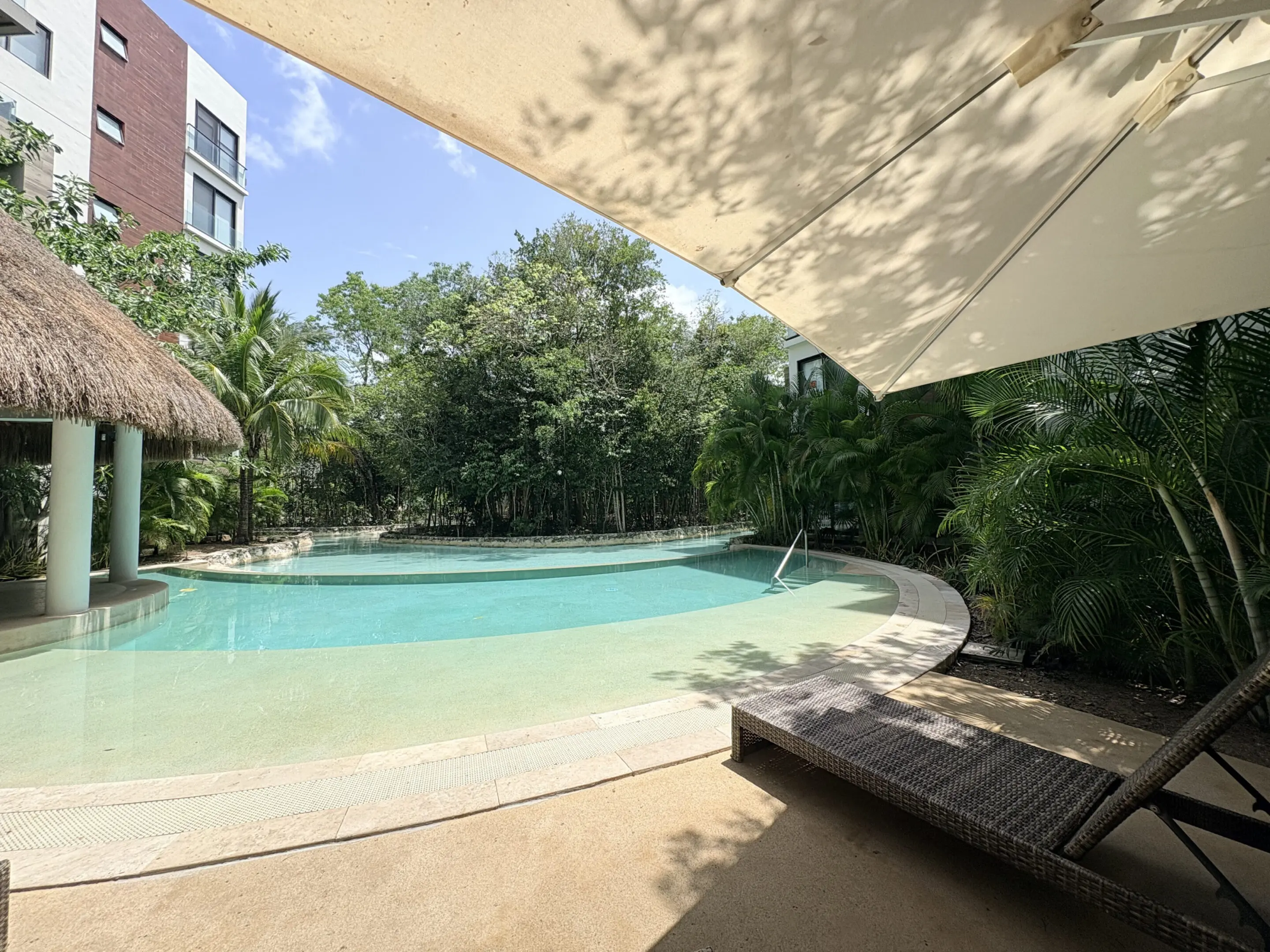 Tropical resort pool with lounge chair