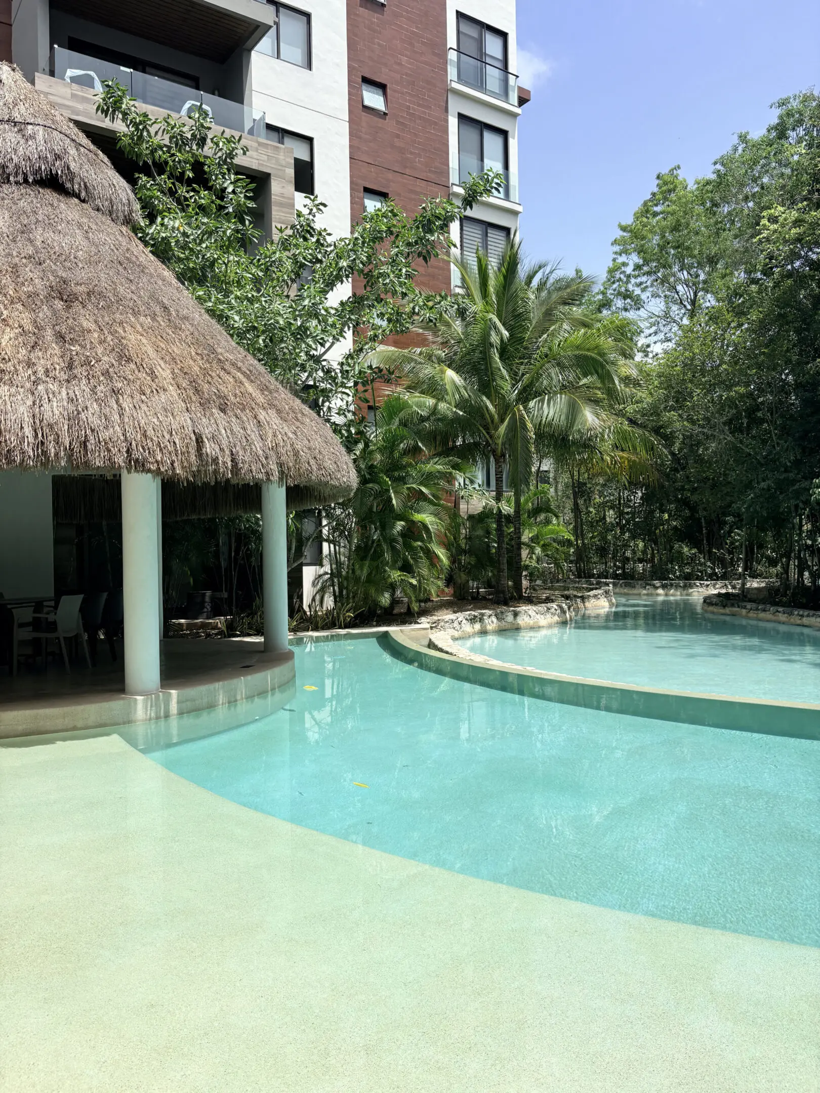 Tropical resort pool with thatched palapa