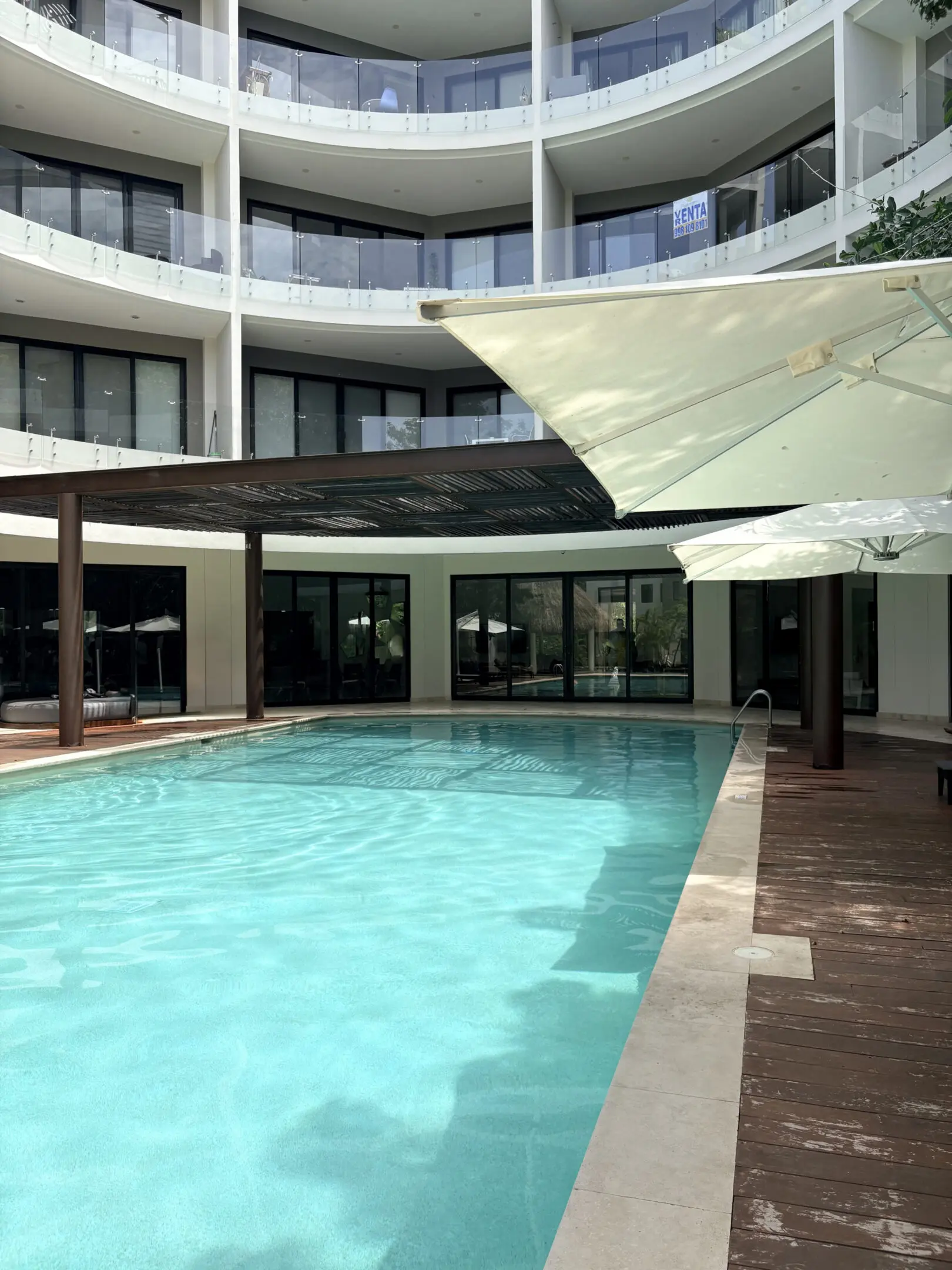 Modern hotel pool with balconies and umbrellas