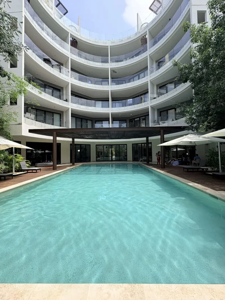 Curved white building with central outdoor pool