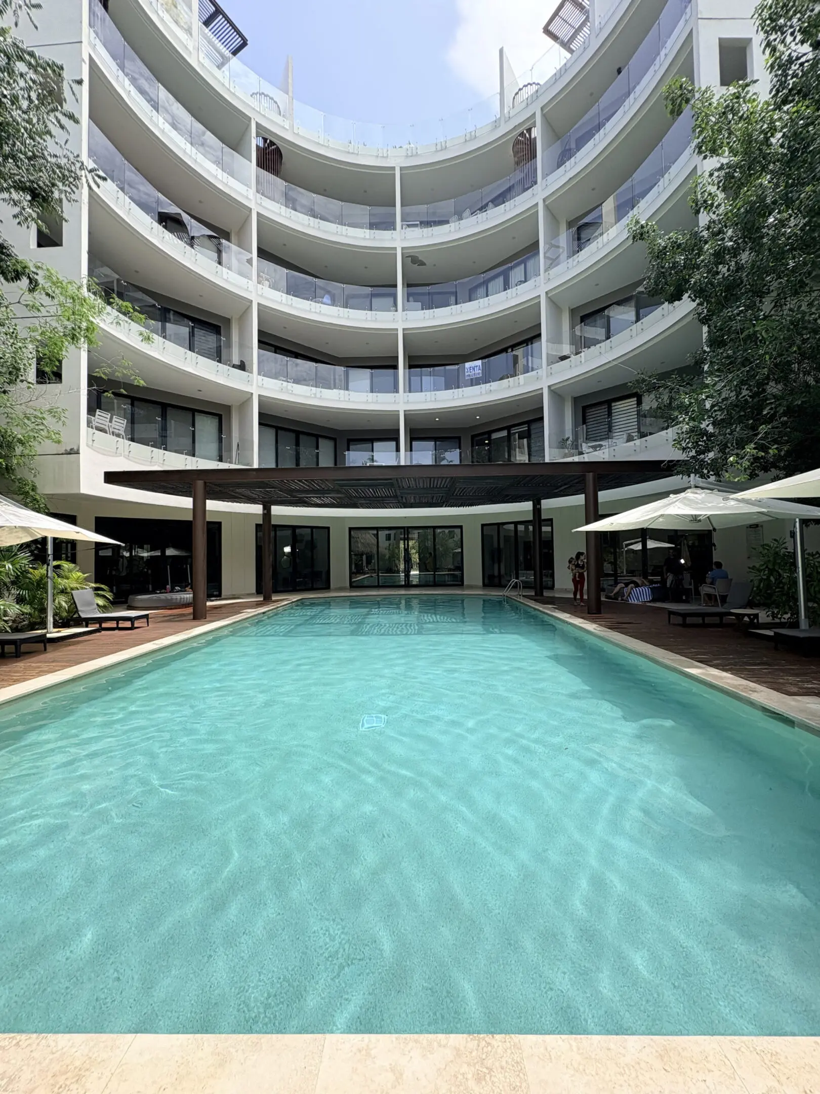 Curved white building with central outdoor pool